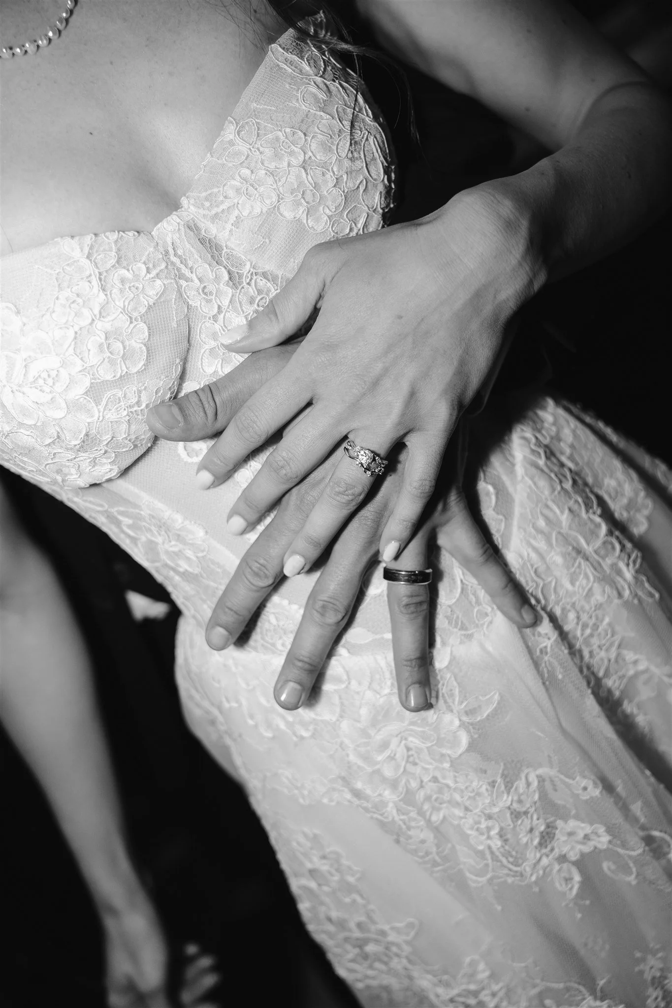 Bride and groom hold hands with their rings visible