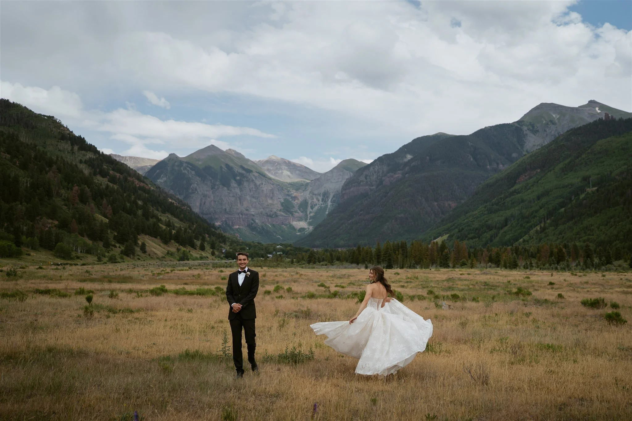 Bride spins in her dress while the groom laughs