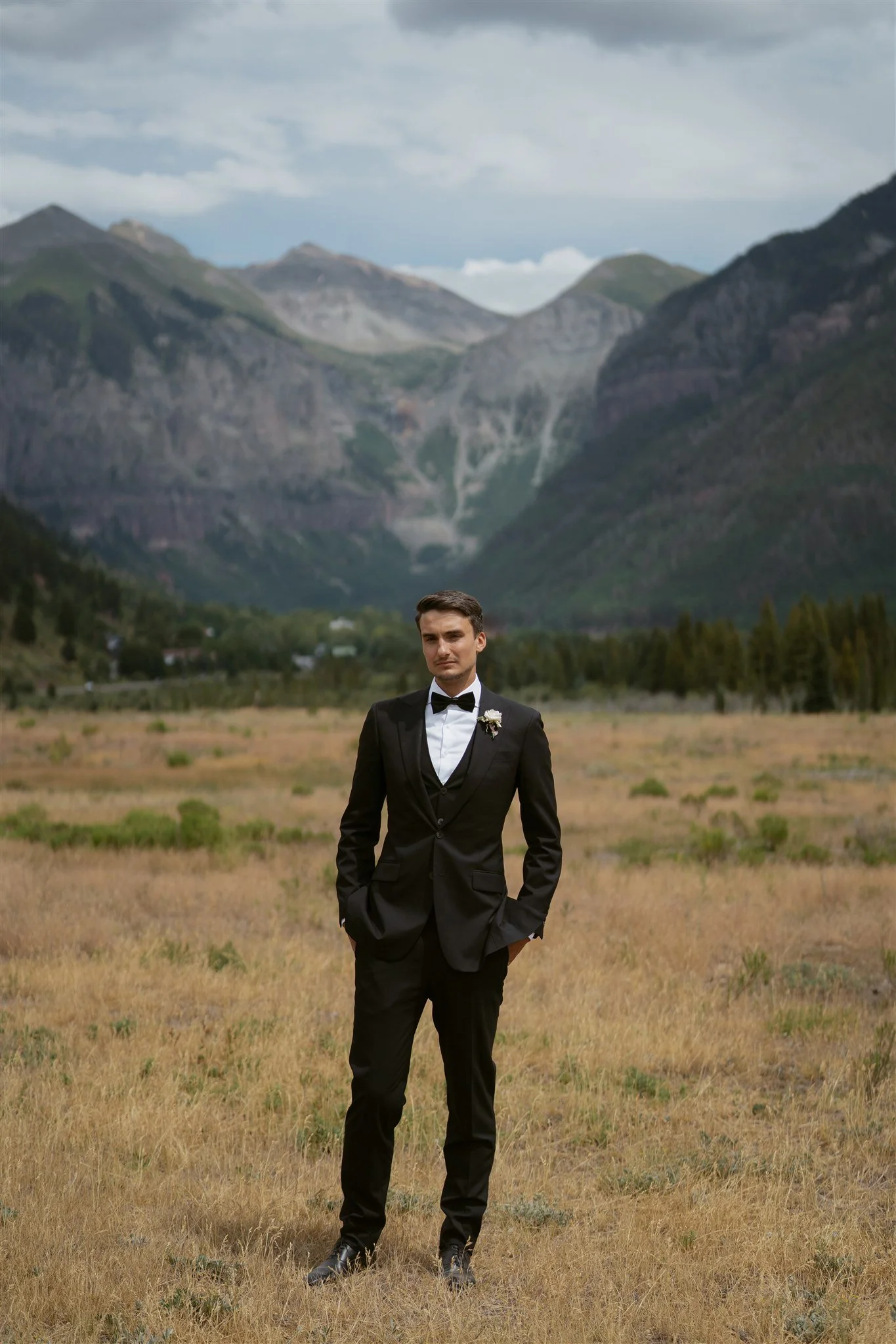 groom poses with the Telluride valley behind him