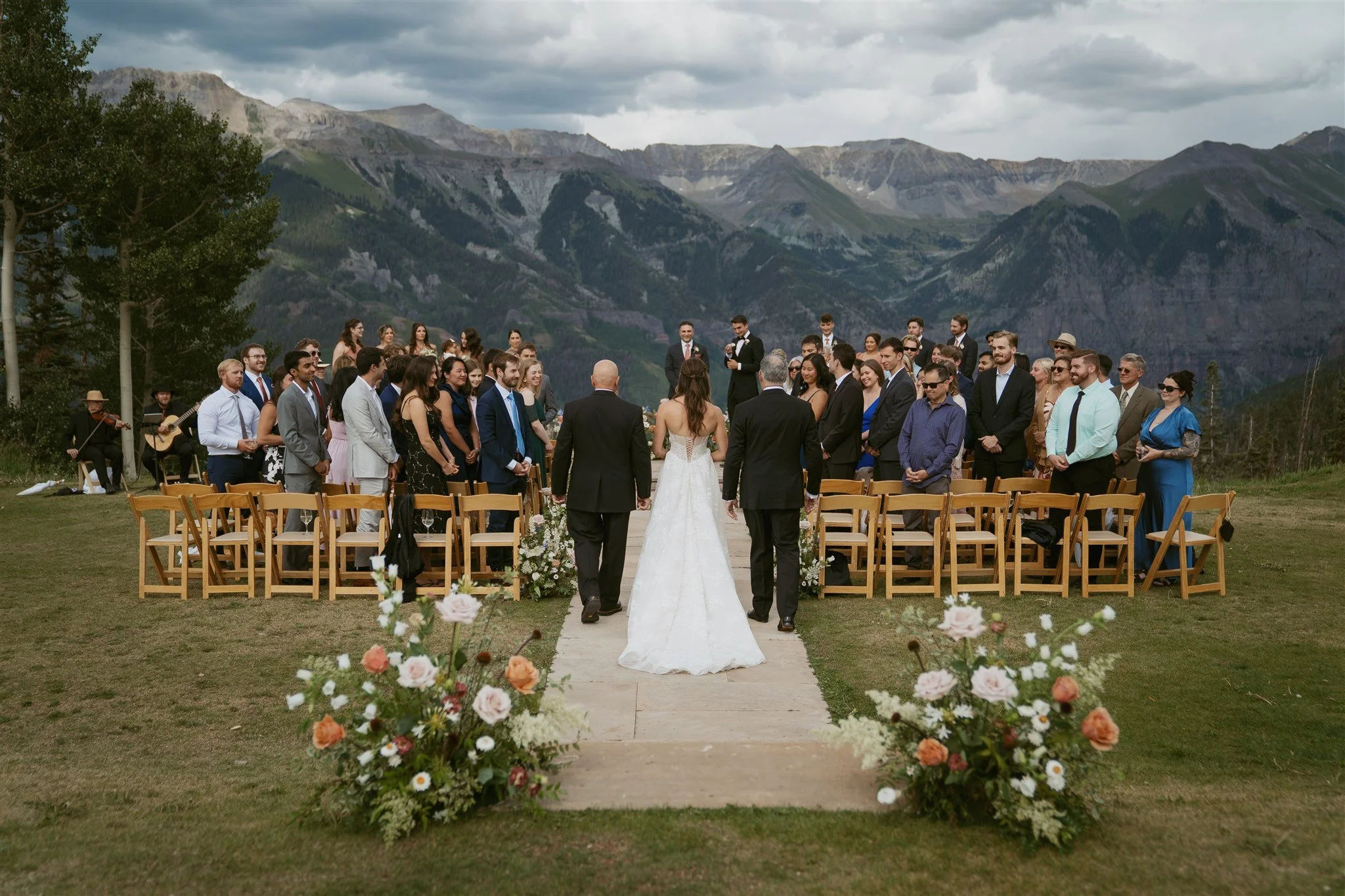 bride walking down the aisle from behind, with the mountains in the background