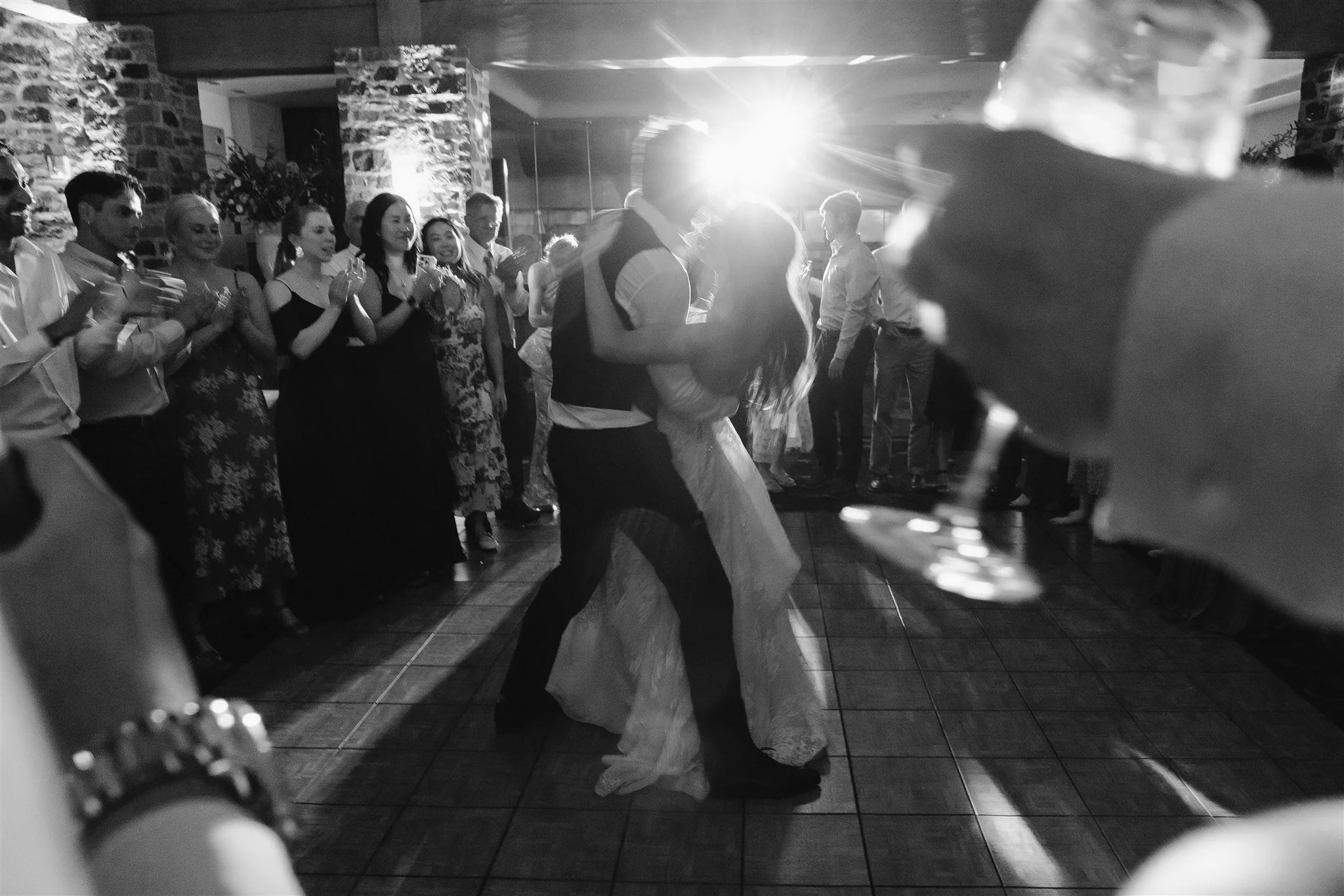 Bride and groom dancing with their guests around them