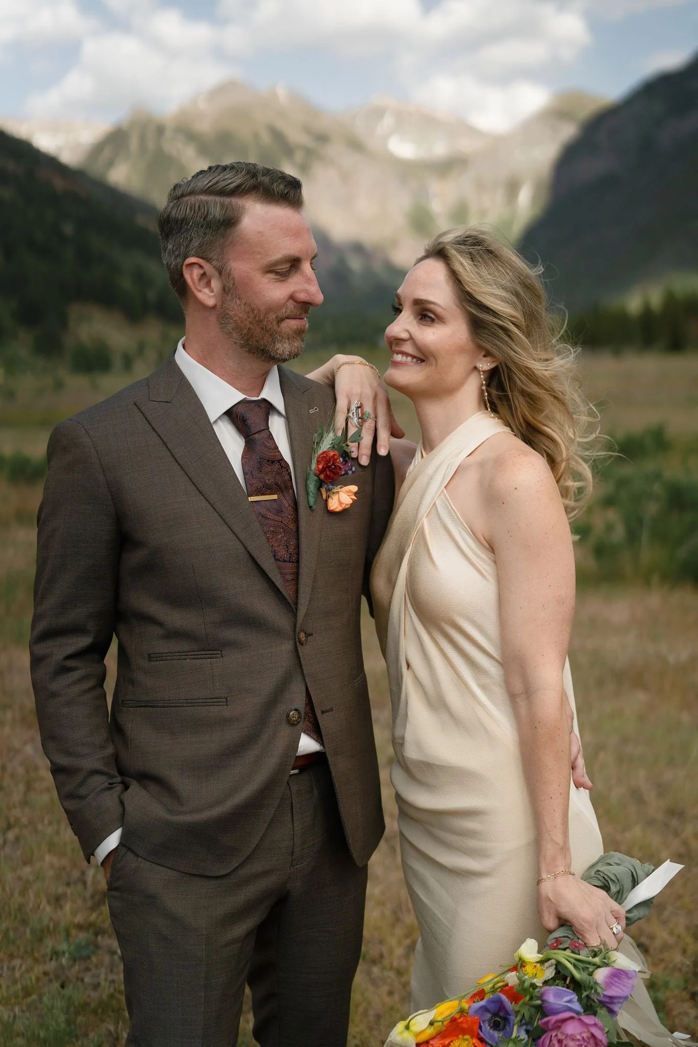 bride and groom smiling towards each other