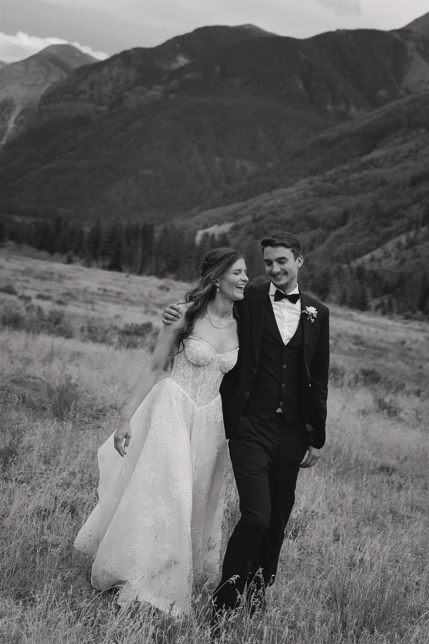 bride and groom laughing and walking in the Telluride valley