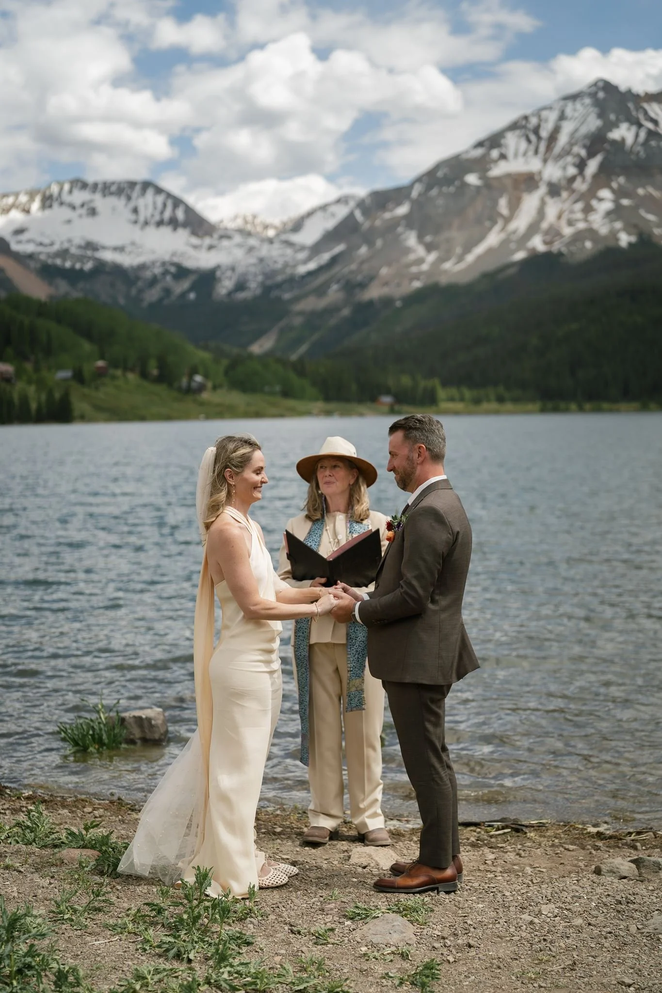 the bride and groom hold hands at the ceremony
