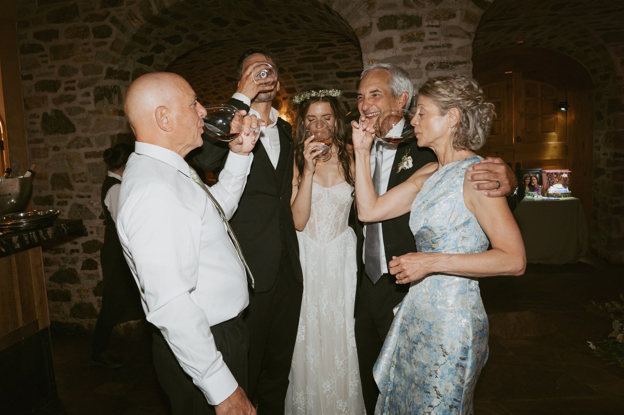 bride and groom and their family members share a whisky