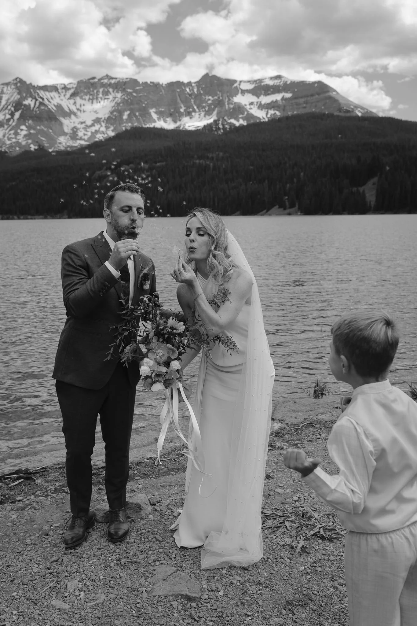 bride and groom blow bubbles towards their nephew