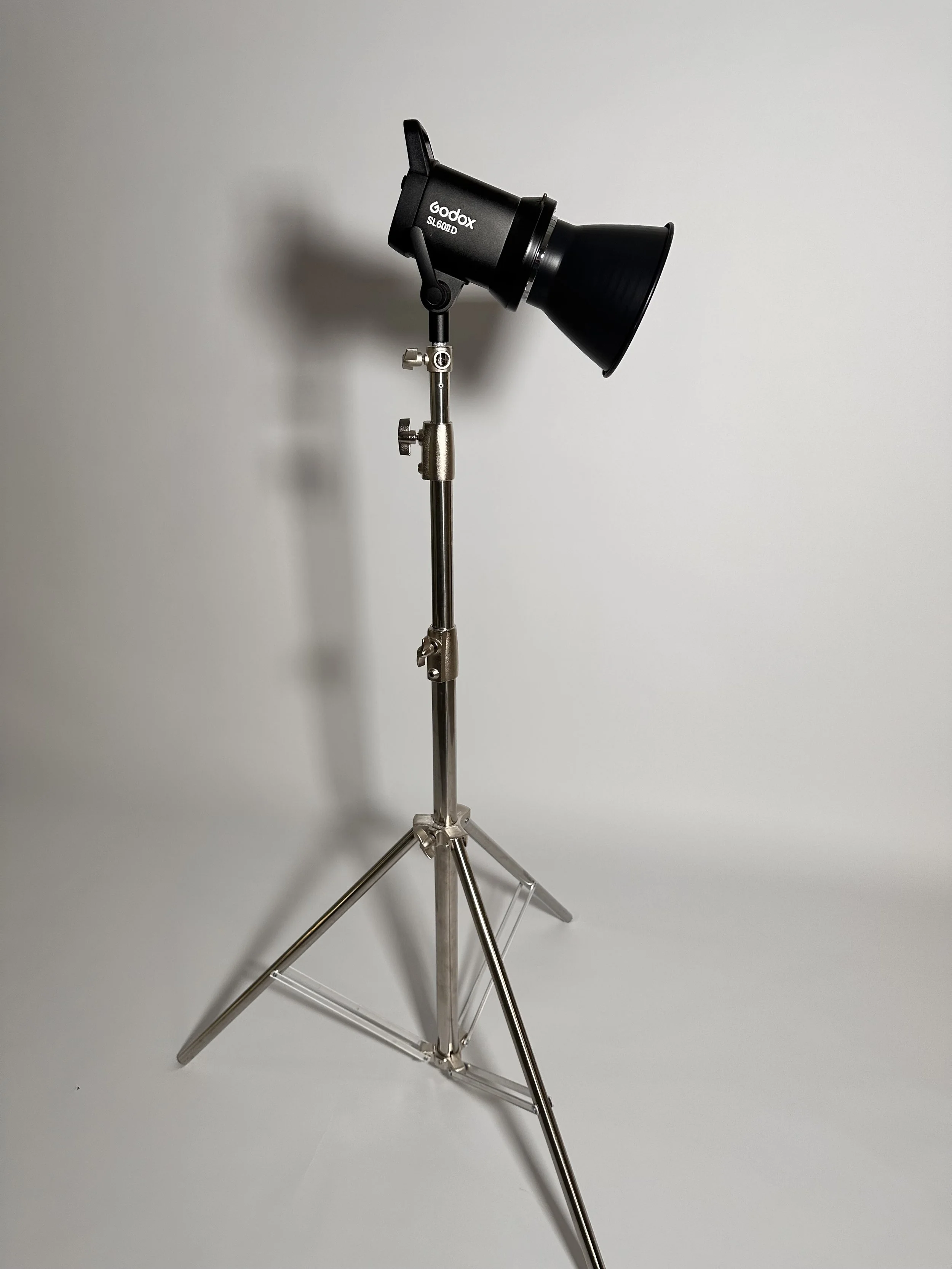 Studio light with adjustable stand against plain white background