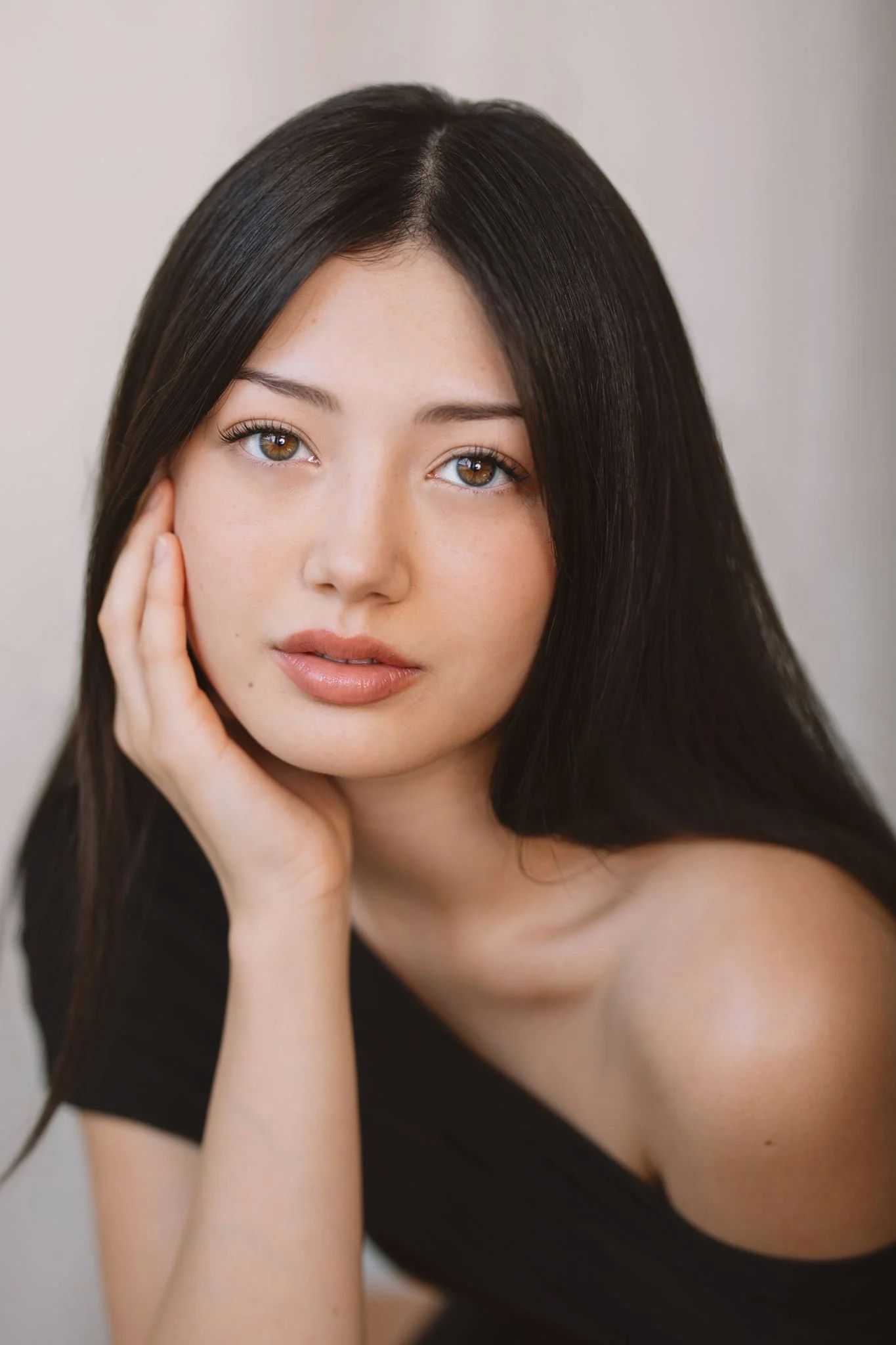 Woman with long dark hair resting her chin on her hand, black top - actor headshot by Tea & Oranges, Montreal portrait photographer
