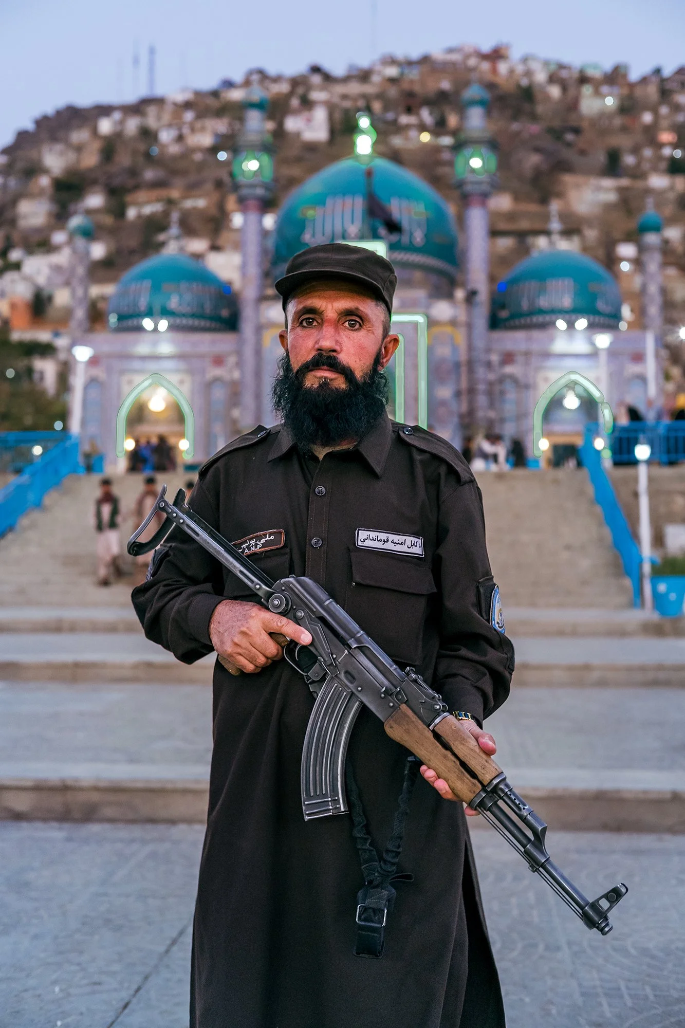 In front of Kabul's magnificent Blue Mosque, a place of daily pilgrimage, an armed Taliban, a former mujahideen who fought to liberate the country from the Russian invasion, poses with solemn pride at sunset in his role as guardian. His presence is i