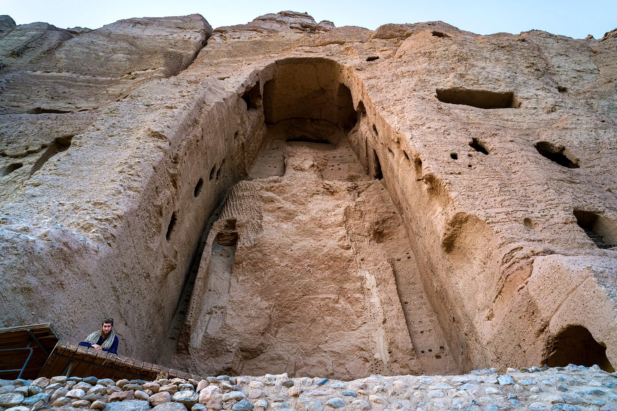 At the foot of the empty niche that once housed one of the Bamiyan Buddhas, a Taliban guard watches over the historic site. In this paradox, between faith and repentance, the guard becomes the symbol of a group torn between the desire to preserve and
