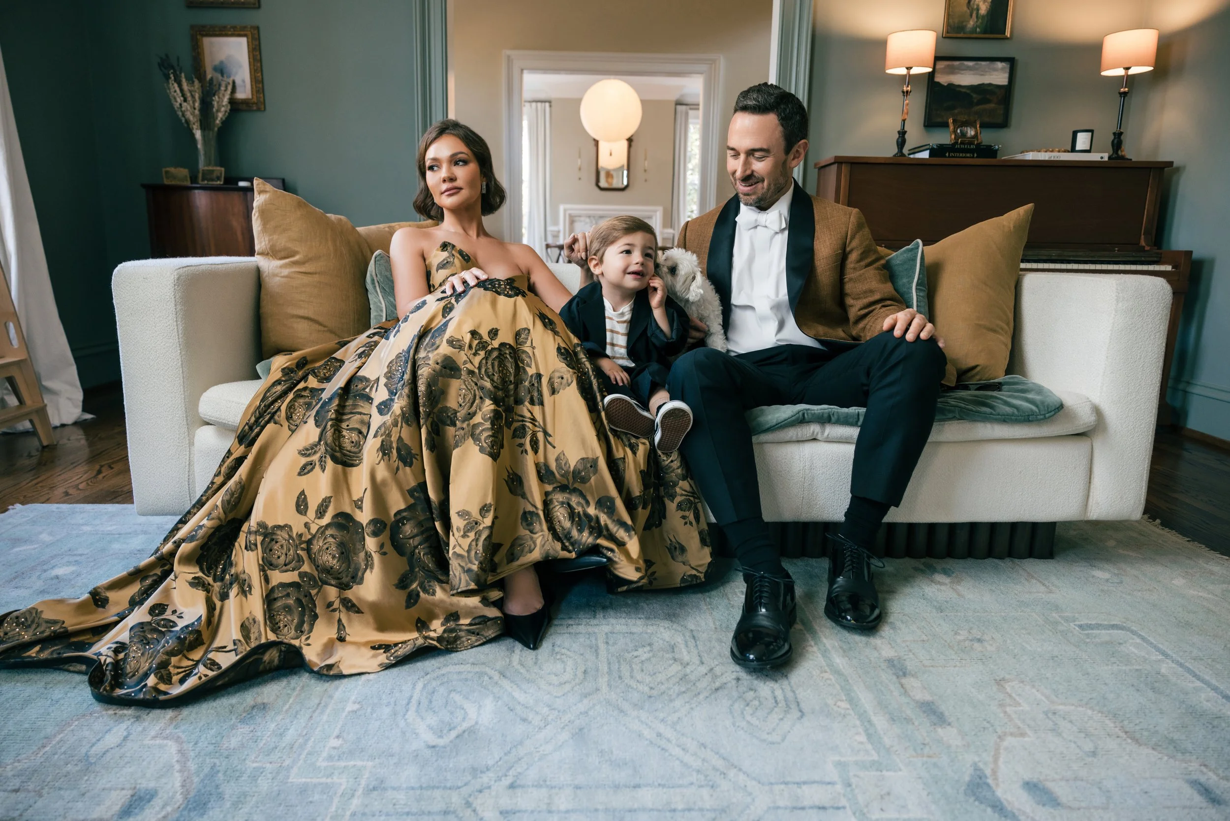 Editorial-style family portrait in a luxury home with parents and child sitting on a sofa in Nashville