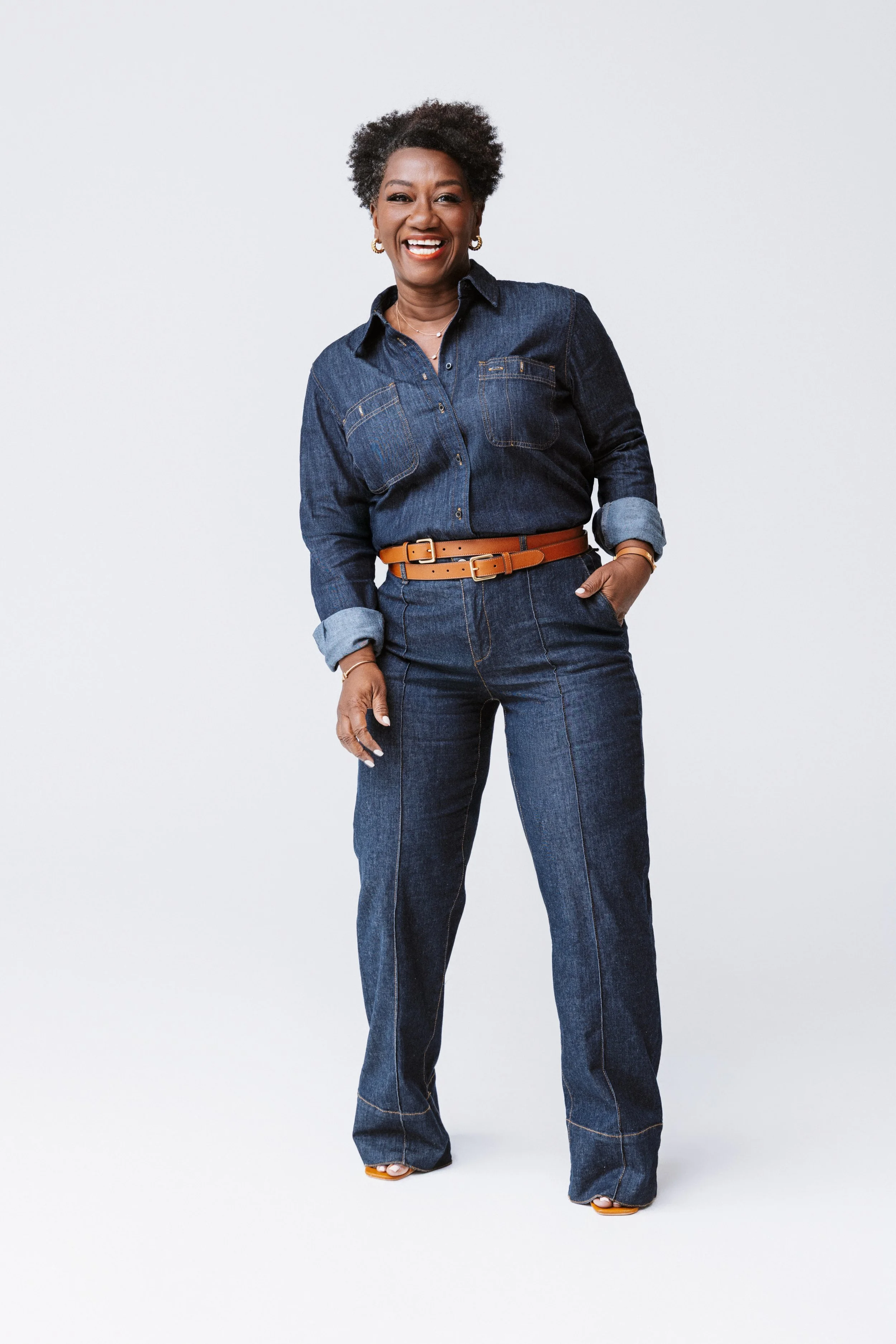 This full-body branding portrait features Tressie McMillan Cottom in a tailored denim look, standing confidently against a clean studio backdrop. Captured by a Nashville Headshot Photographer, the image blends editorial polish with a grounded, approa