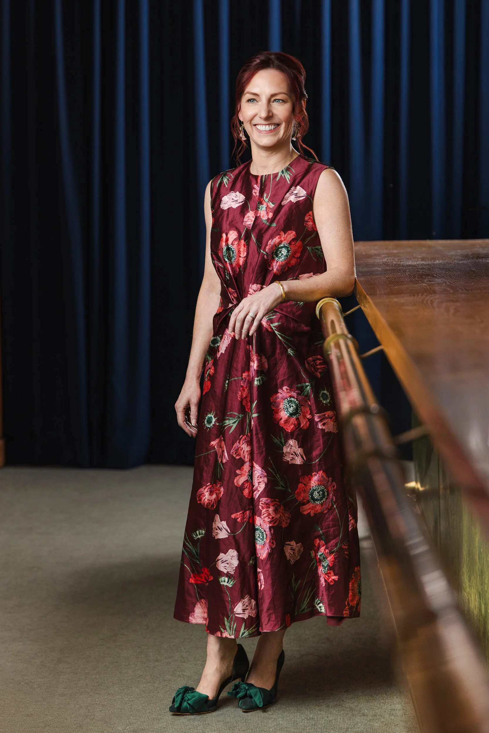 Carrie Kitko smiling on the brass staircase at the Fairlane Hotel, Nashville editorial photography by Tausha Dickinson.