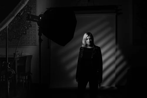 Behind the scenes of a dramatic one-light portrait setup in a dark studio