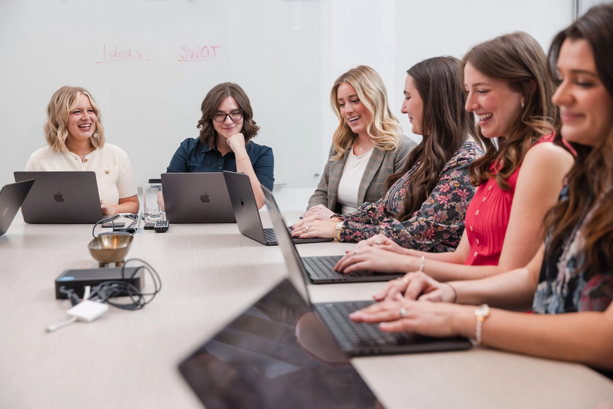Team meeting with laptops around a conference table, representing workflow planning, collaboration, and business systems.