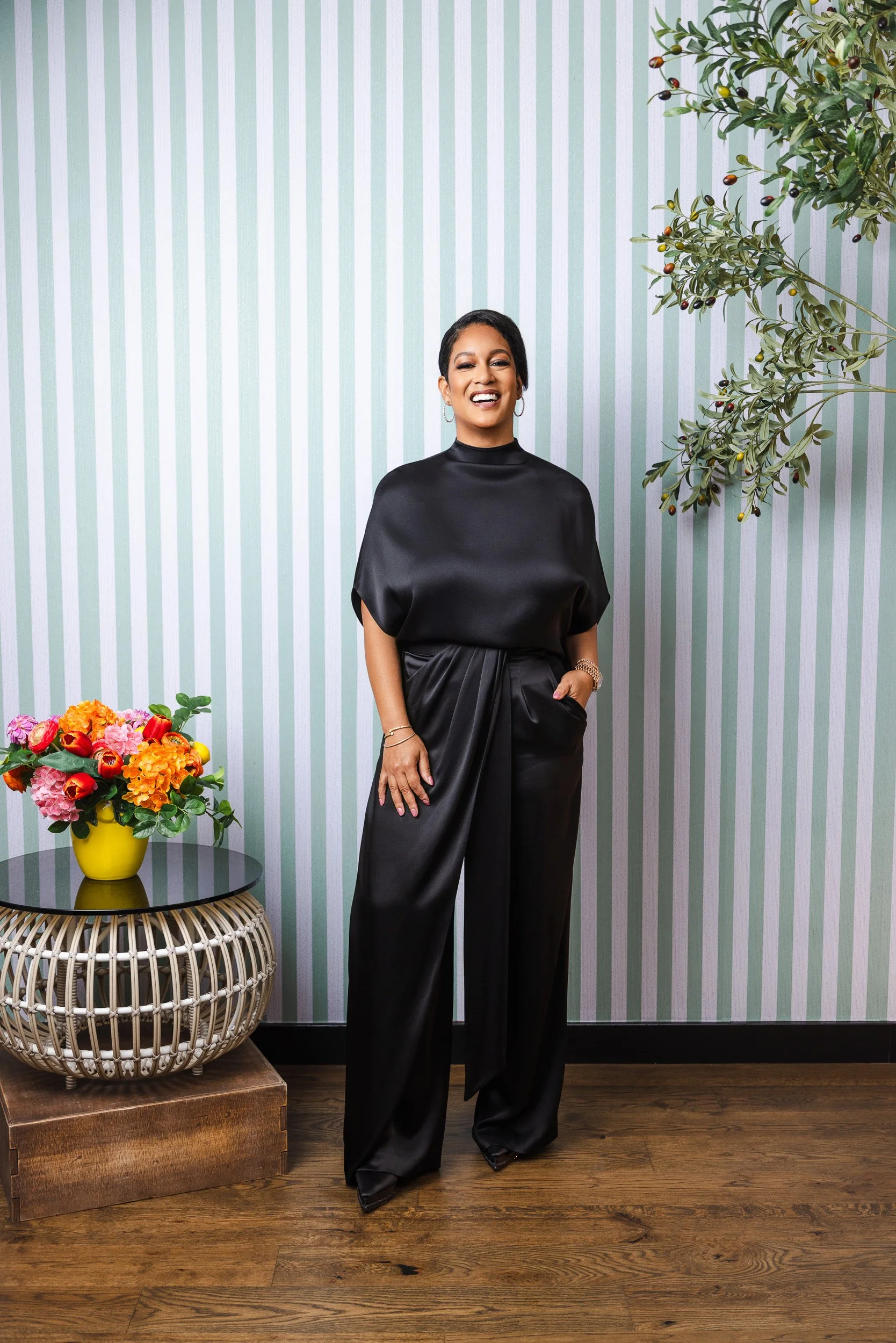 LaDonna Boyd in a black satin top and wide leg pants, photographed against mint striped wallpaper for nFocus Magazine's Model Behavior 2026.