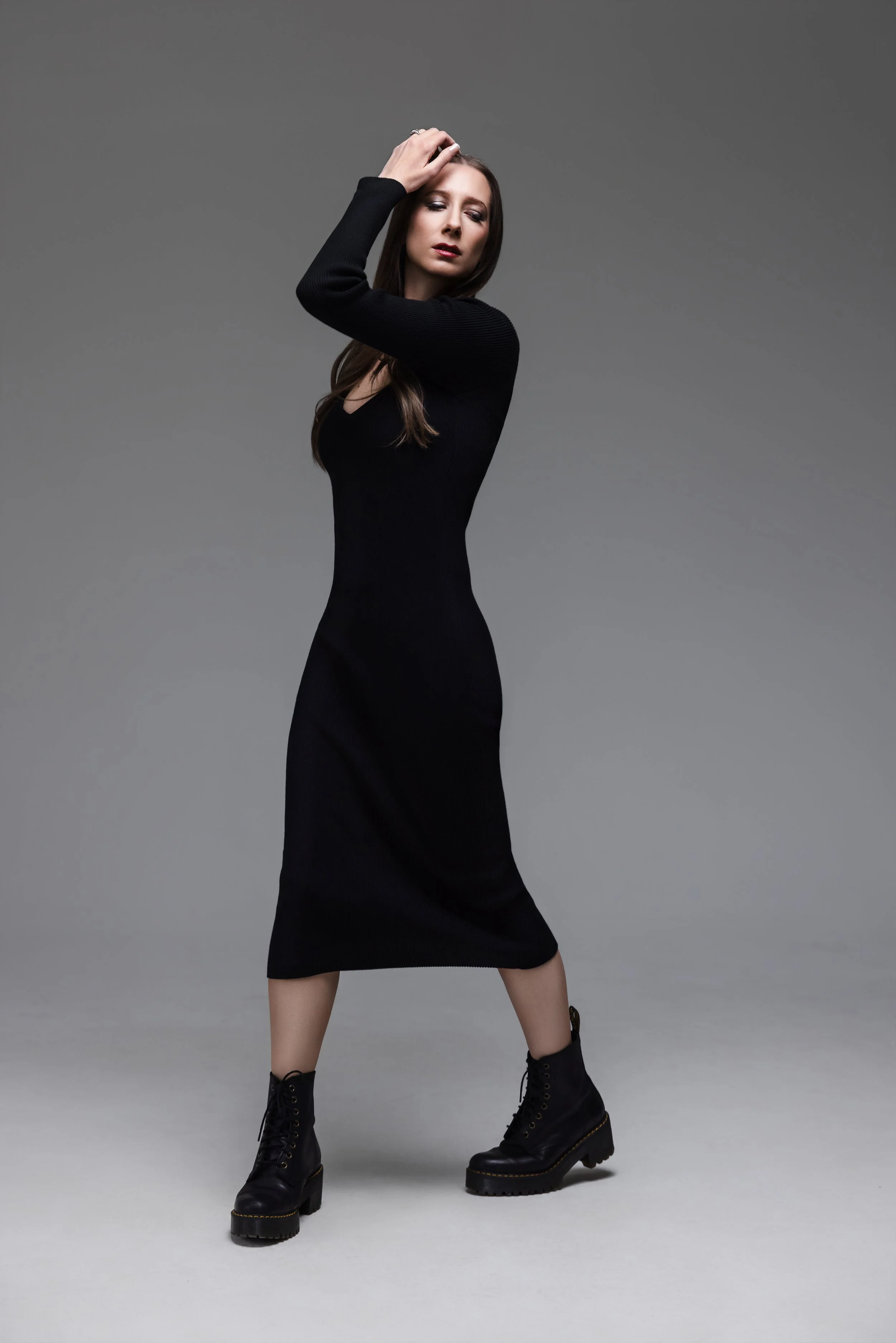 Studio portrait of Nashville singer-songwriter Lauren River in a black dress, standing against a gray backdrop with one-light minimal lighting for a clean, dramatic look.
