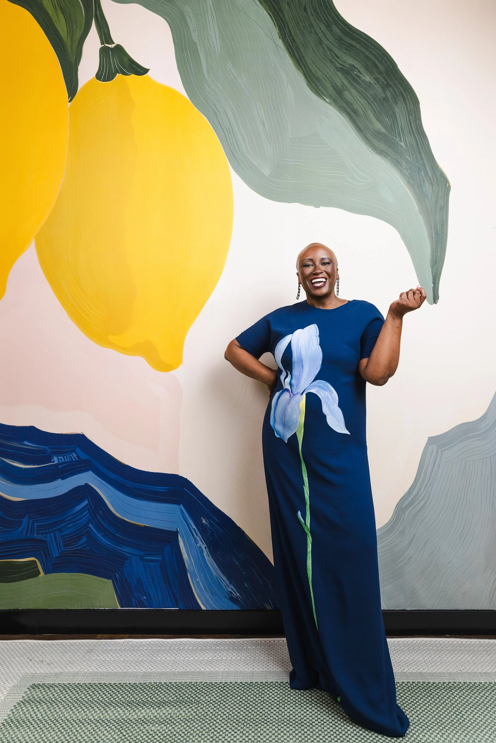 Ciona Rouse laughing in front of the lemon mural at the Fairlane Hotel during her Nashville editorial photography session.