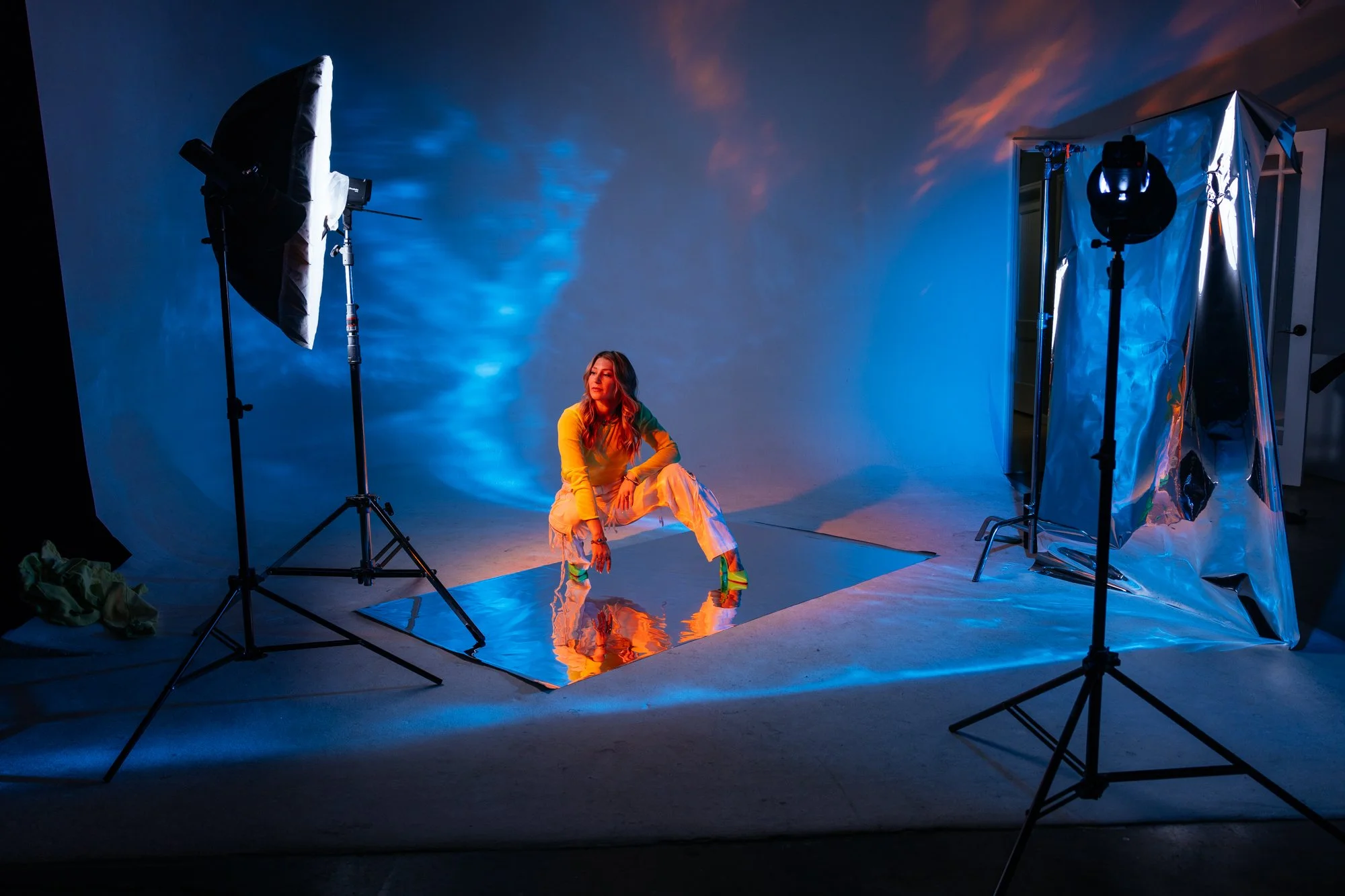 Behind the scenes of a creative studio shoot with dramatic blue lighting and smoke, demonstrating advanced lighting techniques taught in Nashville photography workshops