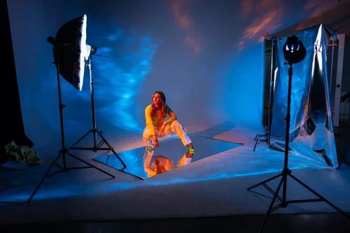 Behind the scenes of a creative studio shoot with dramatic blue lighting and smoke