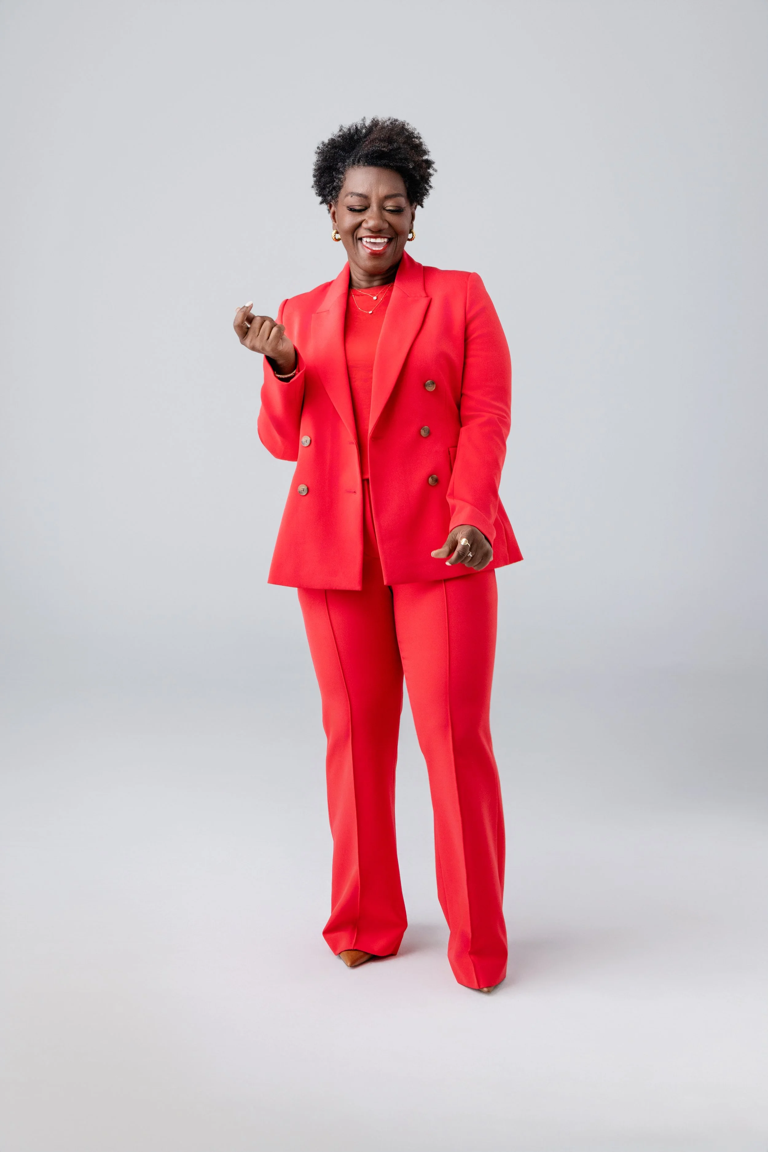 A branding photo full of life, energy, and confidence. Tressie’s mid-motion stance in a red suit brings personality to the forefront—captured by a Nashville Photographer skilled in modern, movement-forward portraits.