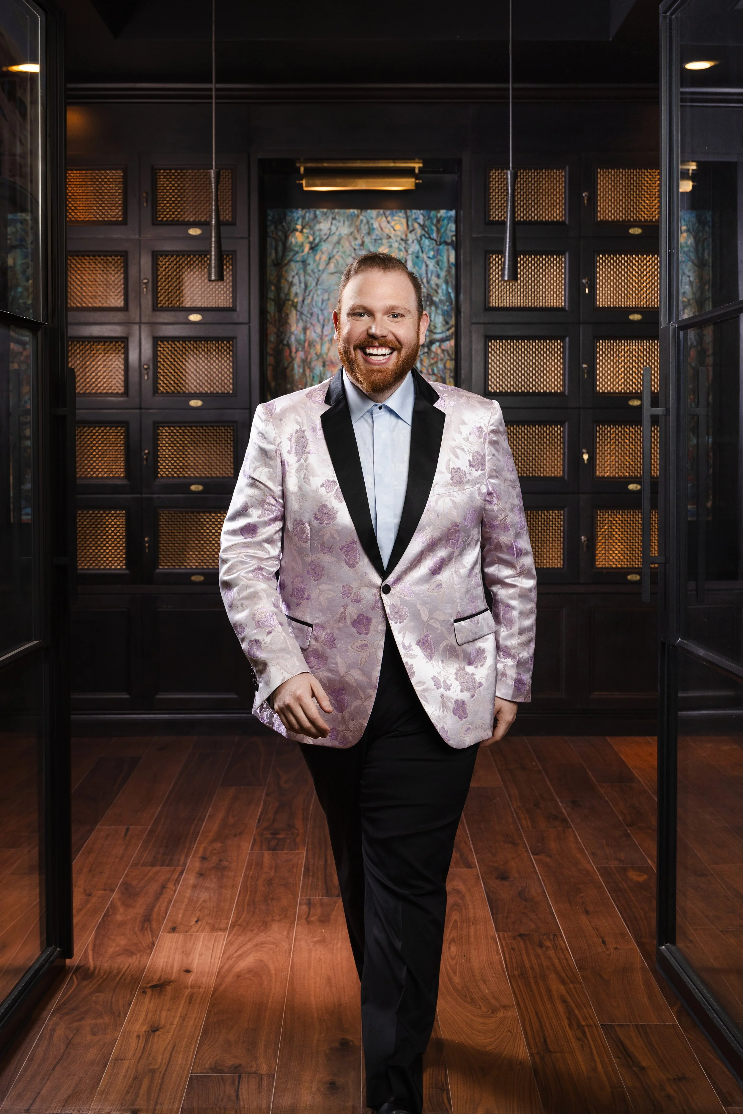 Portrait of Amos for the nFocus Fresh Faces editorial, wearing a pink floral blazer in a dark-toned lounge space at The Manning in Nashville, photographed by Tausha Dickinson.