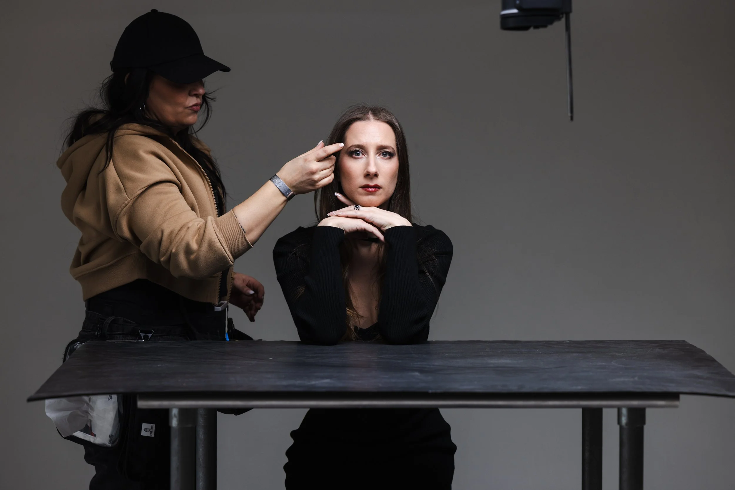 Behind-the-scenes of Lauren Rivers portrait session with makeup artist adjusting her look under controlled studio lighting