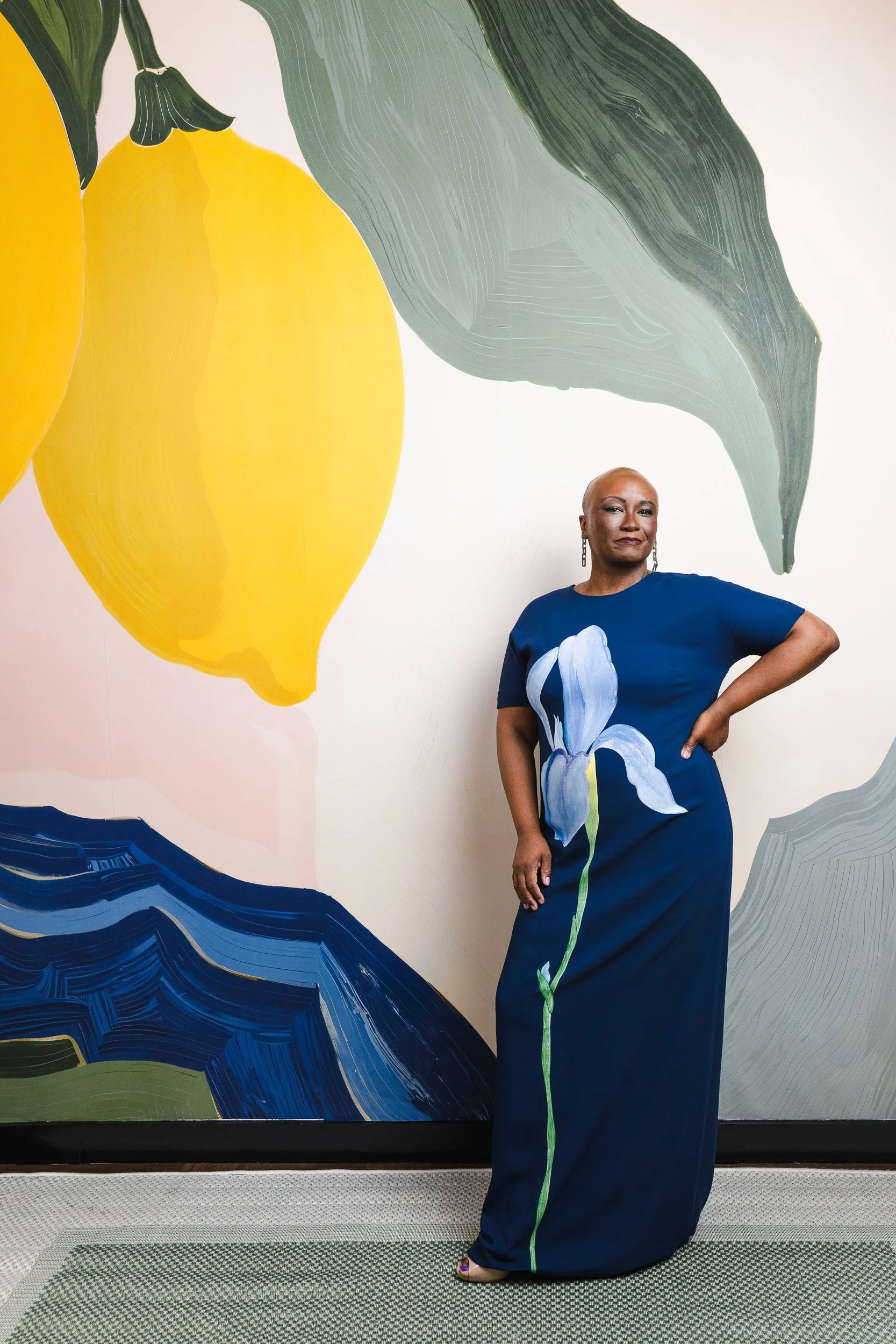Ciona Rouse standing in front of a colorful lemon and leaf mural, the setting for her nFocus Magazine Model Behavior 2026 cover shot.