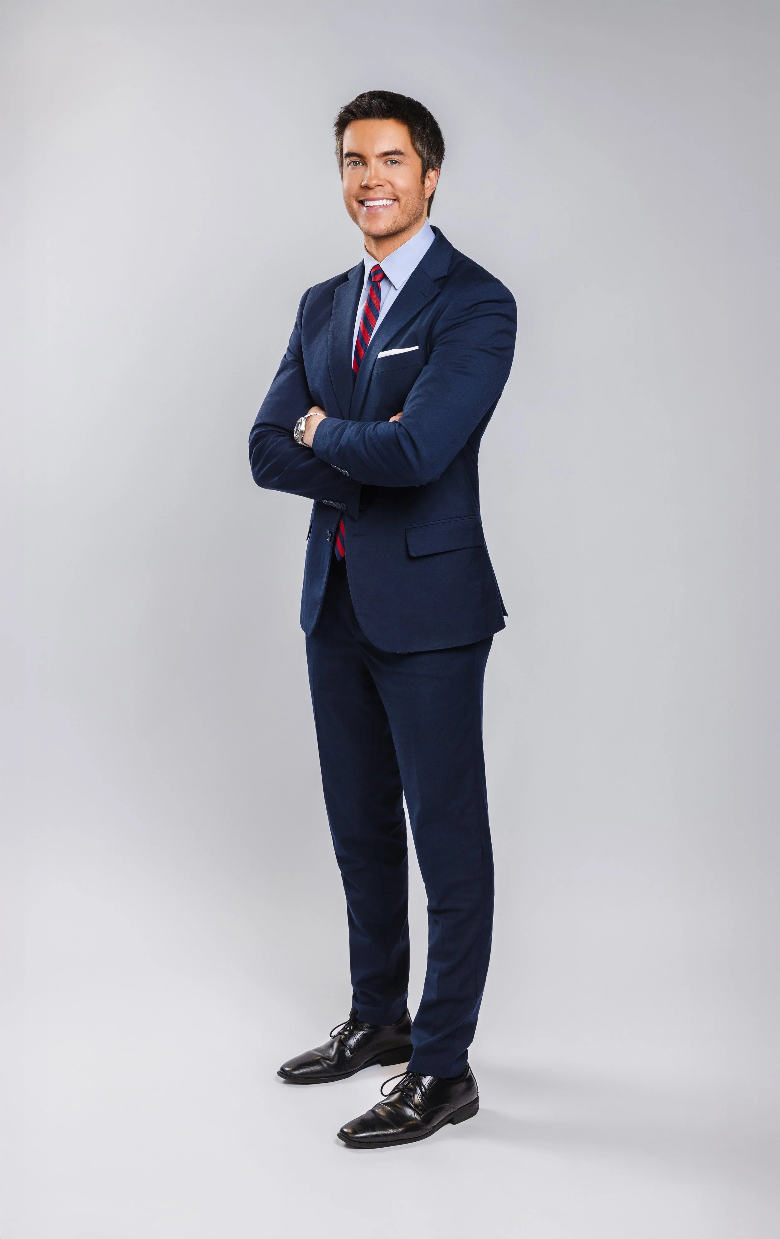 Full-body studio portrait of a WSMV news anchor in a navy suit, photographed by Tausha Dickinson.
