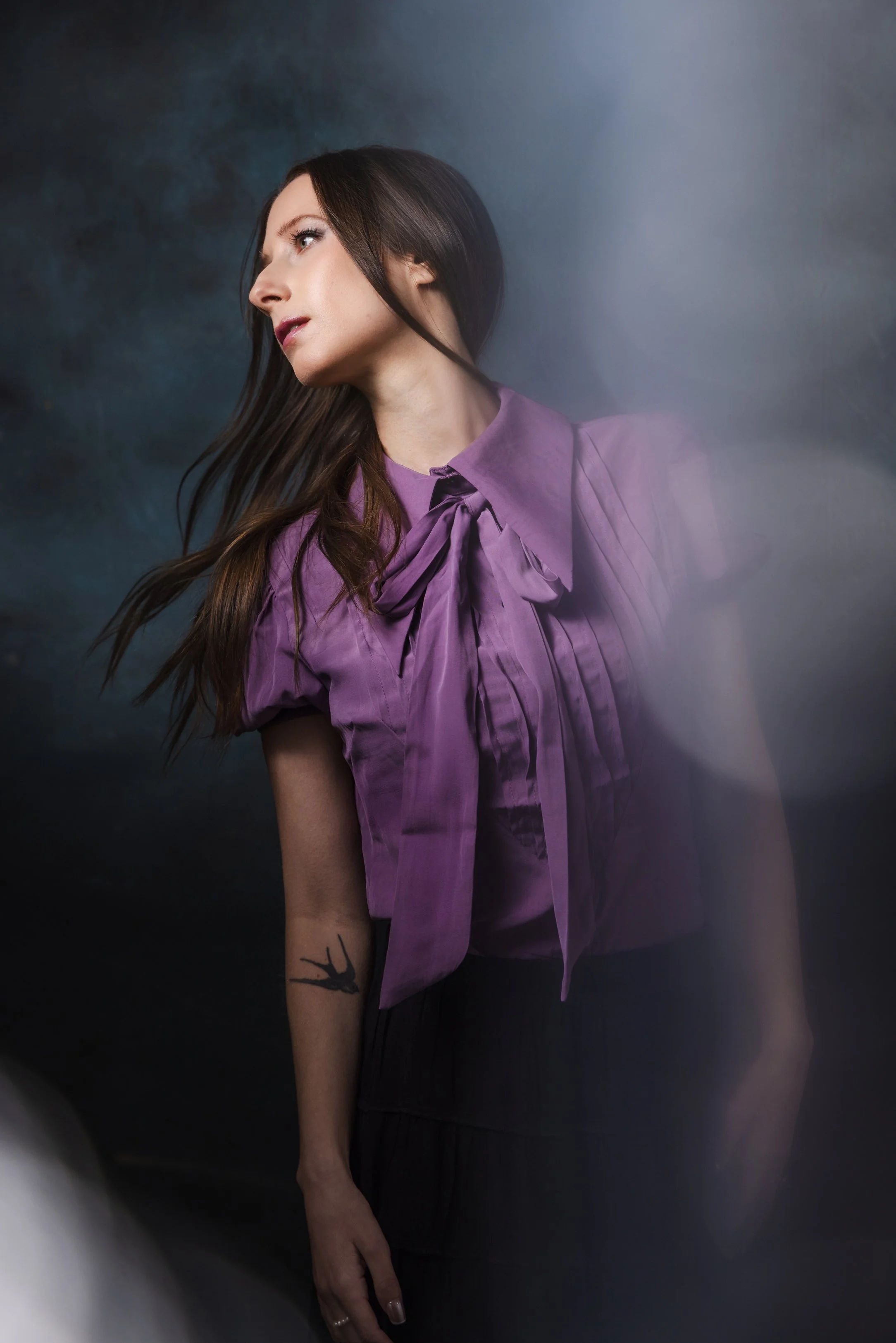 Editorial style portrait of a woman in a purple blouse, used to illustrate creativity and talent in a photography business.