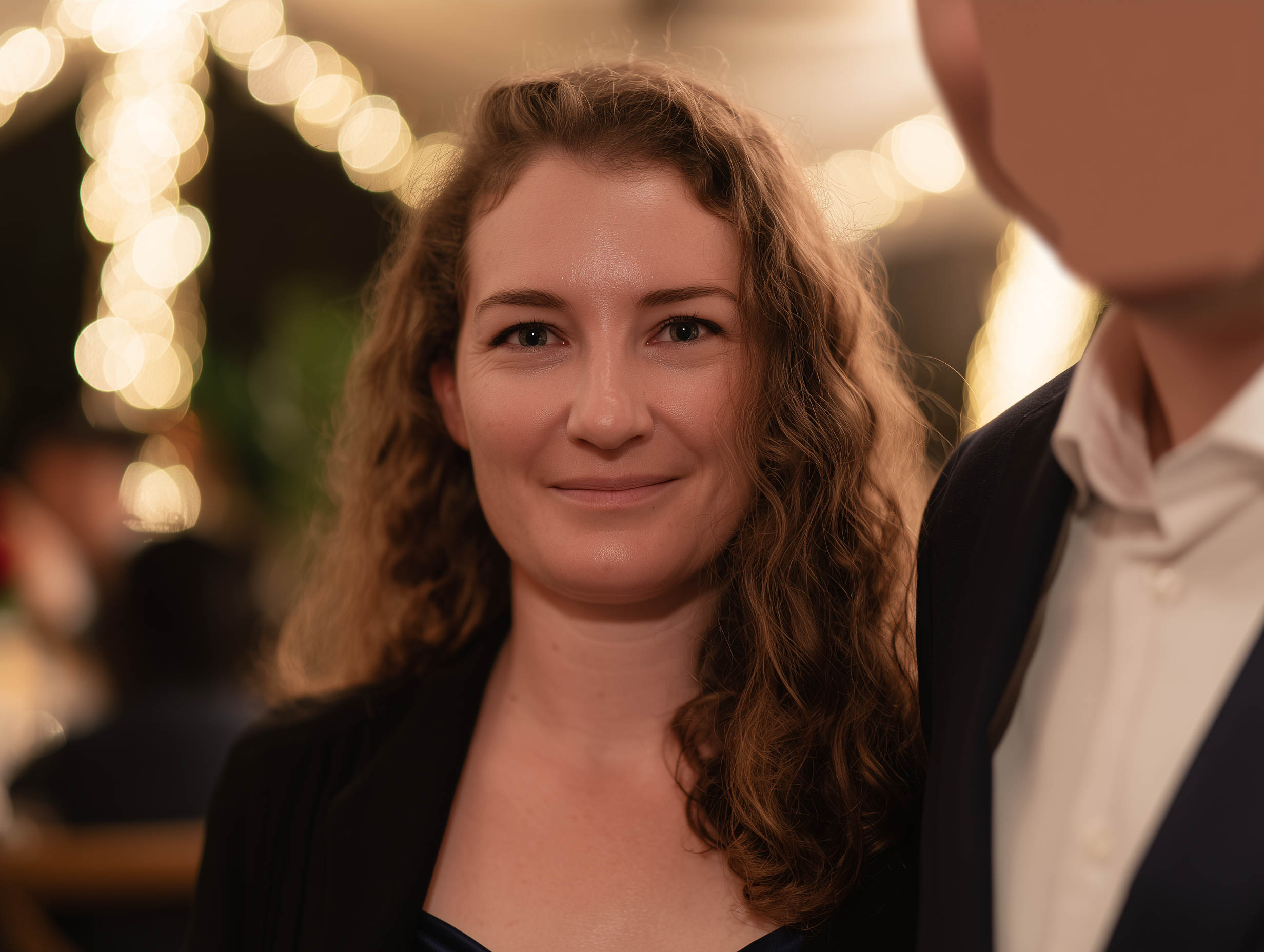 AI-generated example of common LinkedIn headshot mistake: event photo background with distracting bokeh lights and cropped subject beside another person