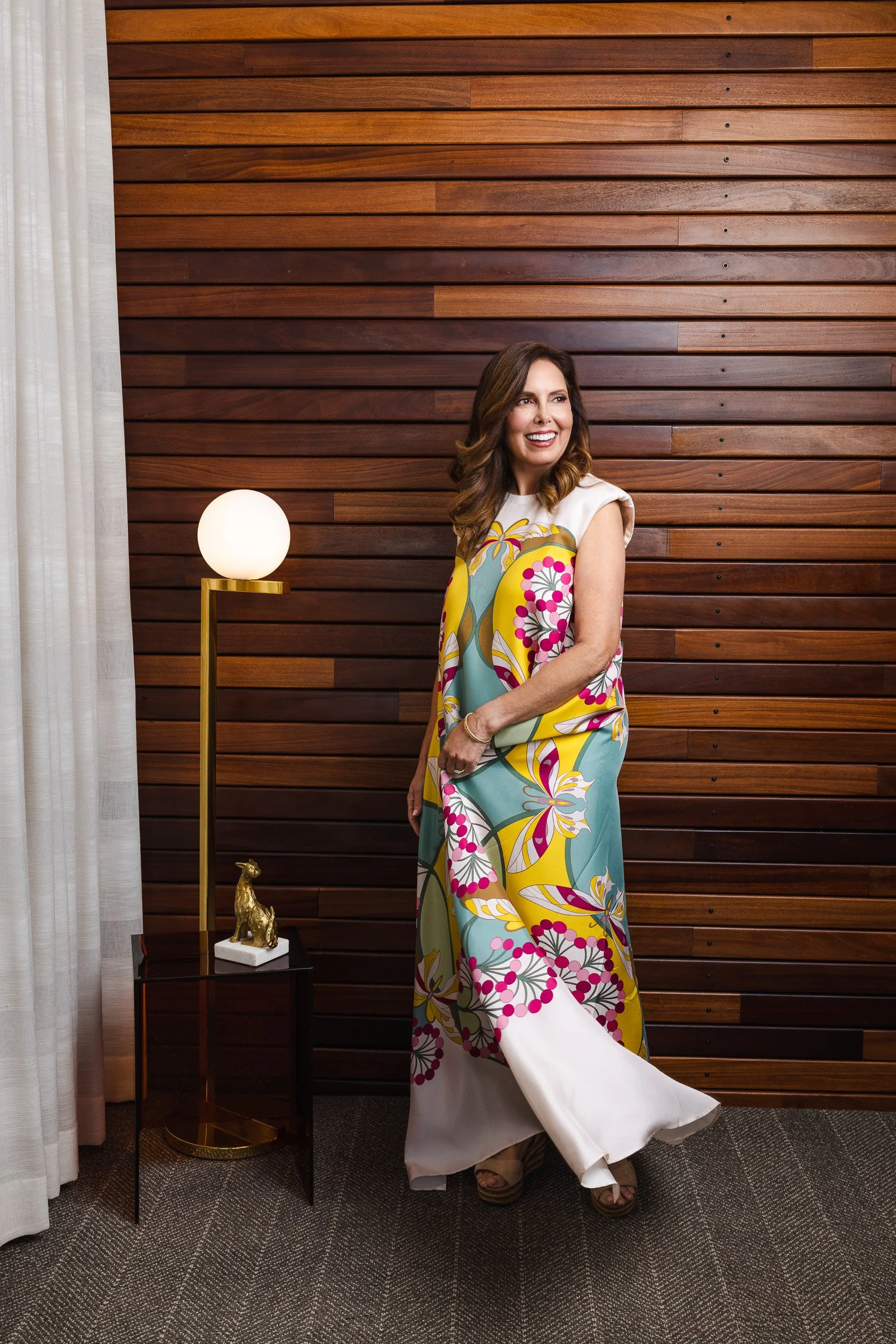 Renee Bates's colorful print dress caught in motion against the wood slat wall at the Fairlane Hotel, Nashville.