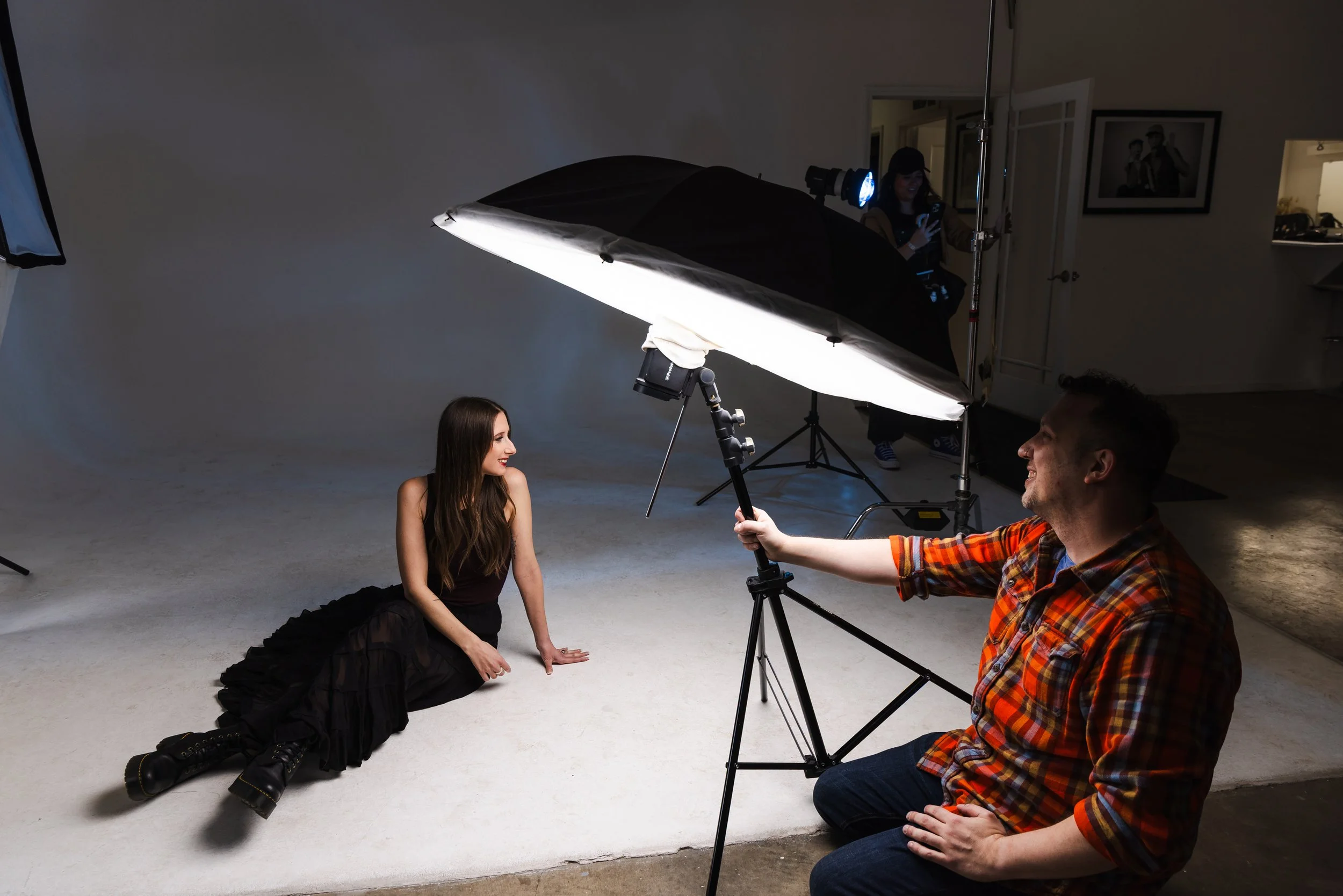 Behind the scenes of a low-angle portrait setup using a large stripbox softlight, demonstrating intentional lighting direction in a Nashville photography workshop