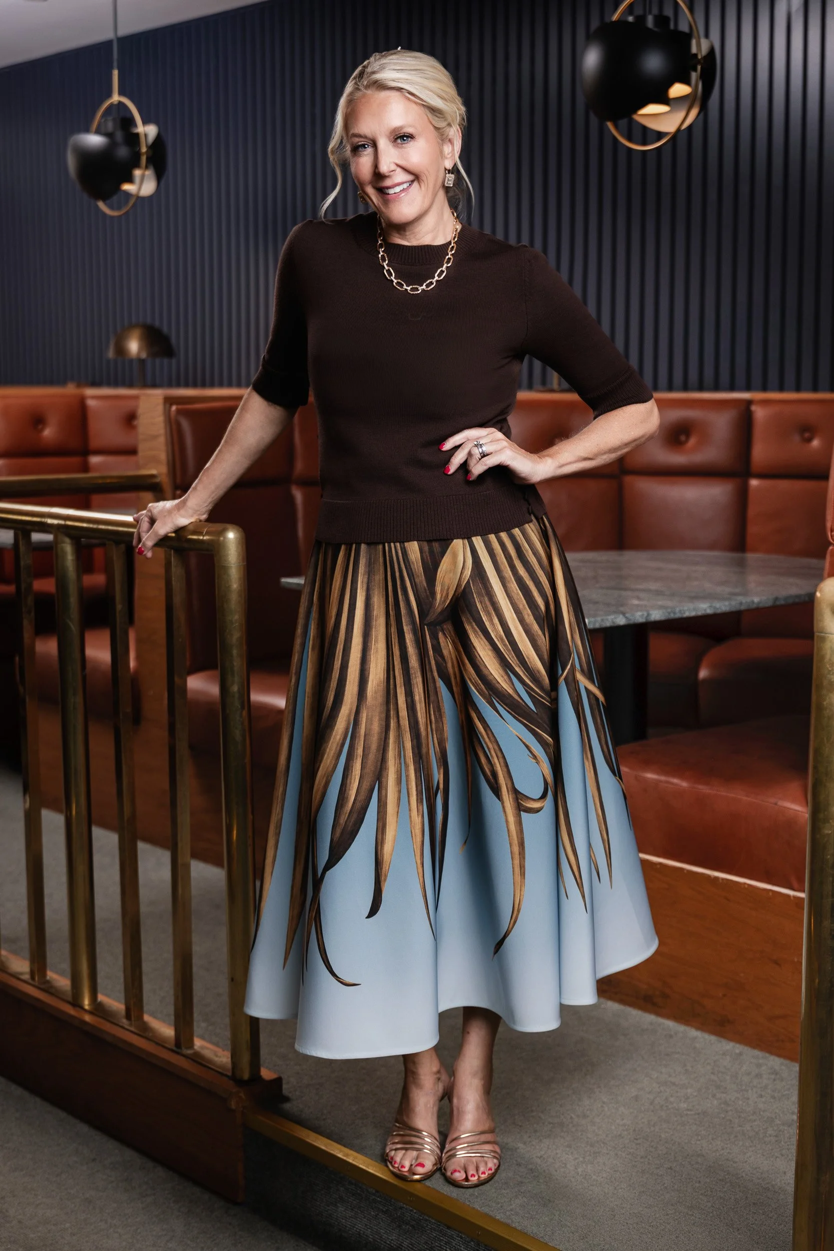 Caroline Cook standing near the leather booth and pendant lighting inside the Fairlane Hotel bar during her Nashville editorial photography session.