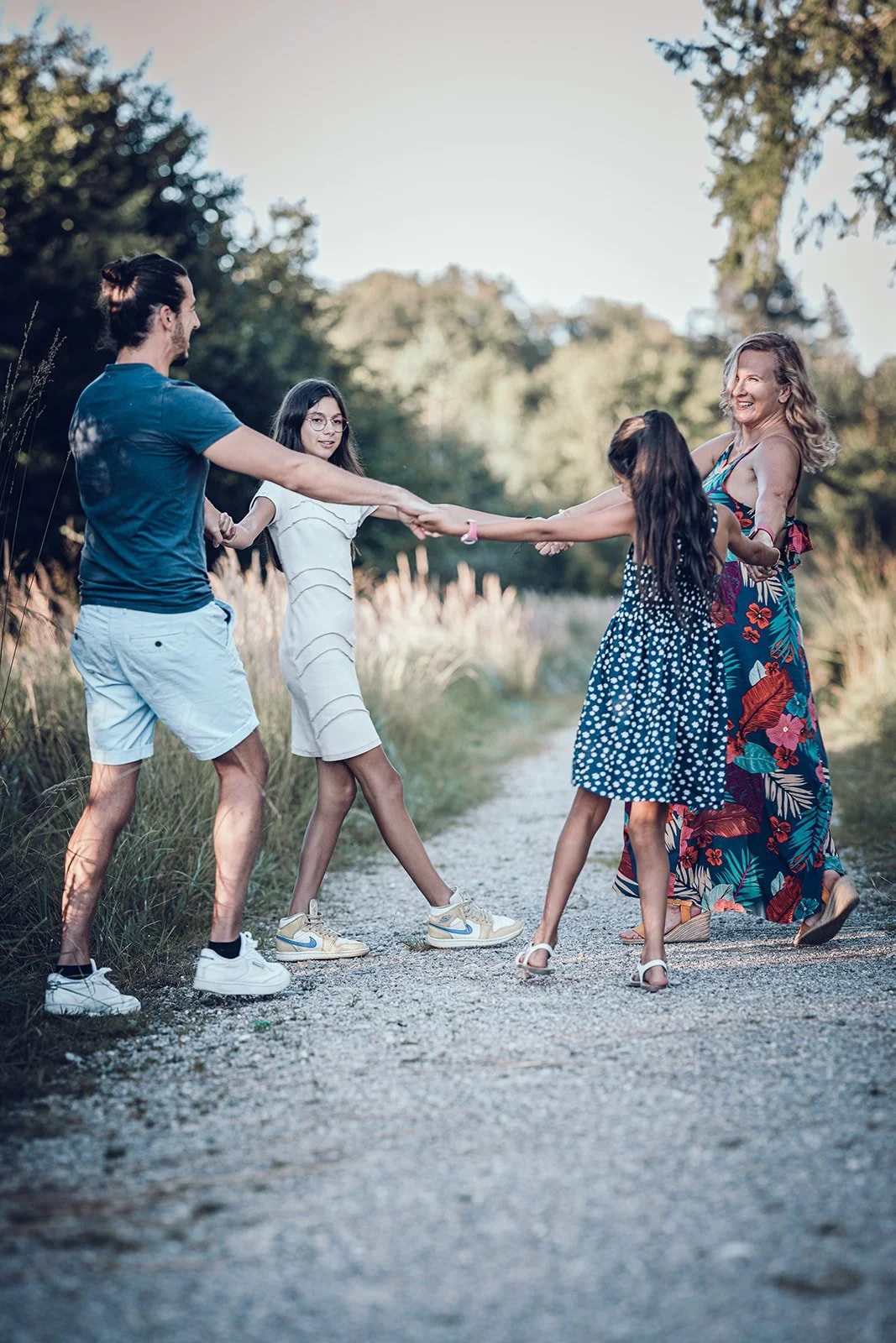 Familienfotografie in München – Familie tanzt auf Weg im Wald