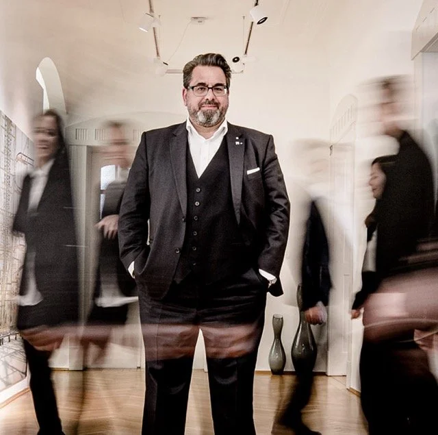 Authentische Businessfotografie in München – Unternehmer im Fokus, Team in Bewegung im Hintergrund