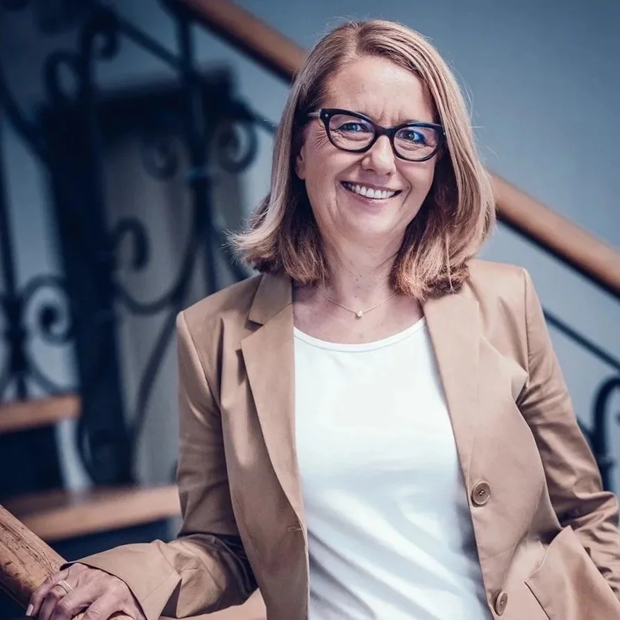 Businessportrait einer Unternehmerin in München, natürliche Haltung, professionell und zugänglich fotografiert.