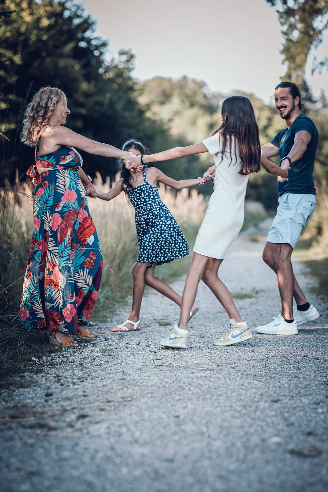 Familienfotografie in München – Familie tanzt auf Weg im Wald