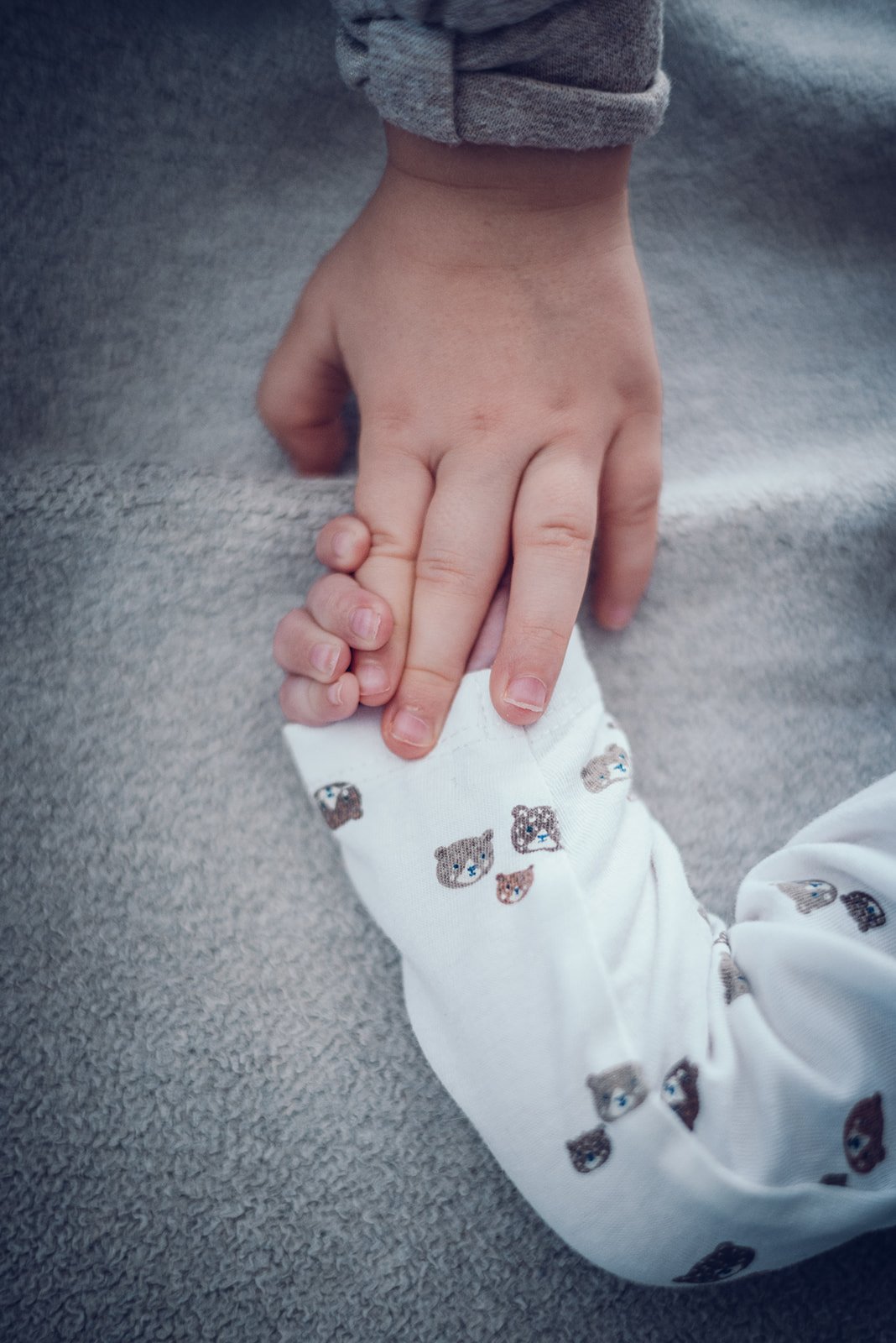 Ruhiger Moment zwischen großer Schwester und Neugeborenem – natürliche Newbornfotografie in München