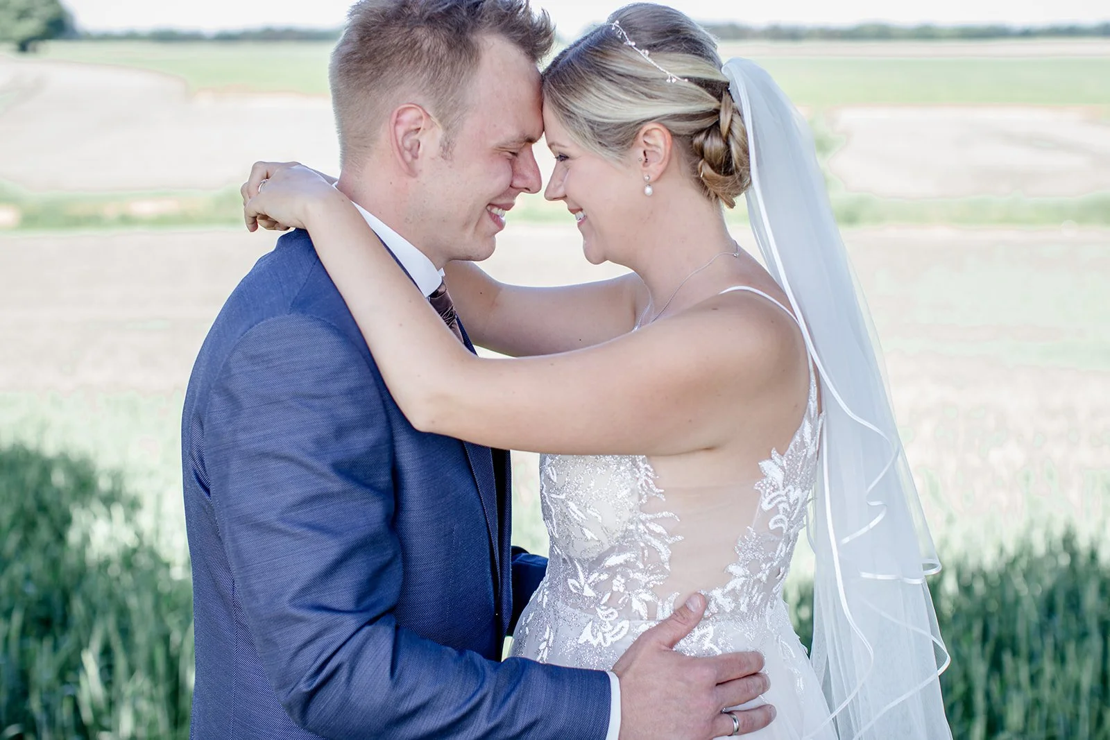 Braut und Bräutigam in inniger Umarmung beim Paarshooting im Grünen