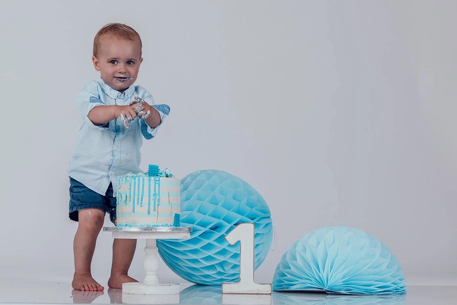 Baby beim Cake Smash Shooting mit Geburtstagstorte im Fotostudio in München