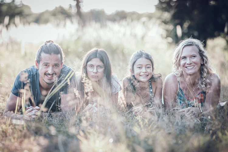 Familie liegt im Gras im Abendlicht