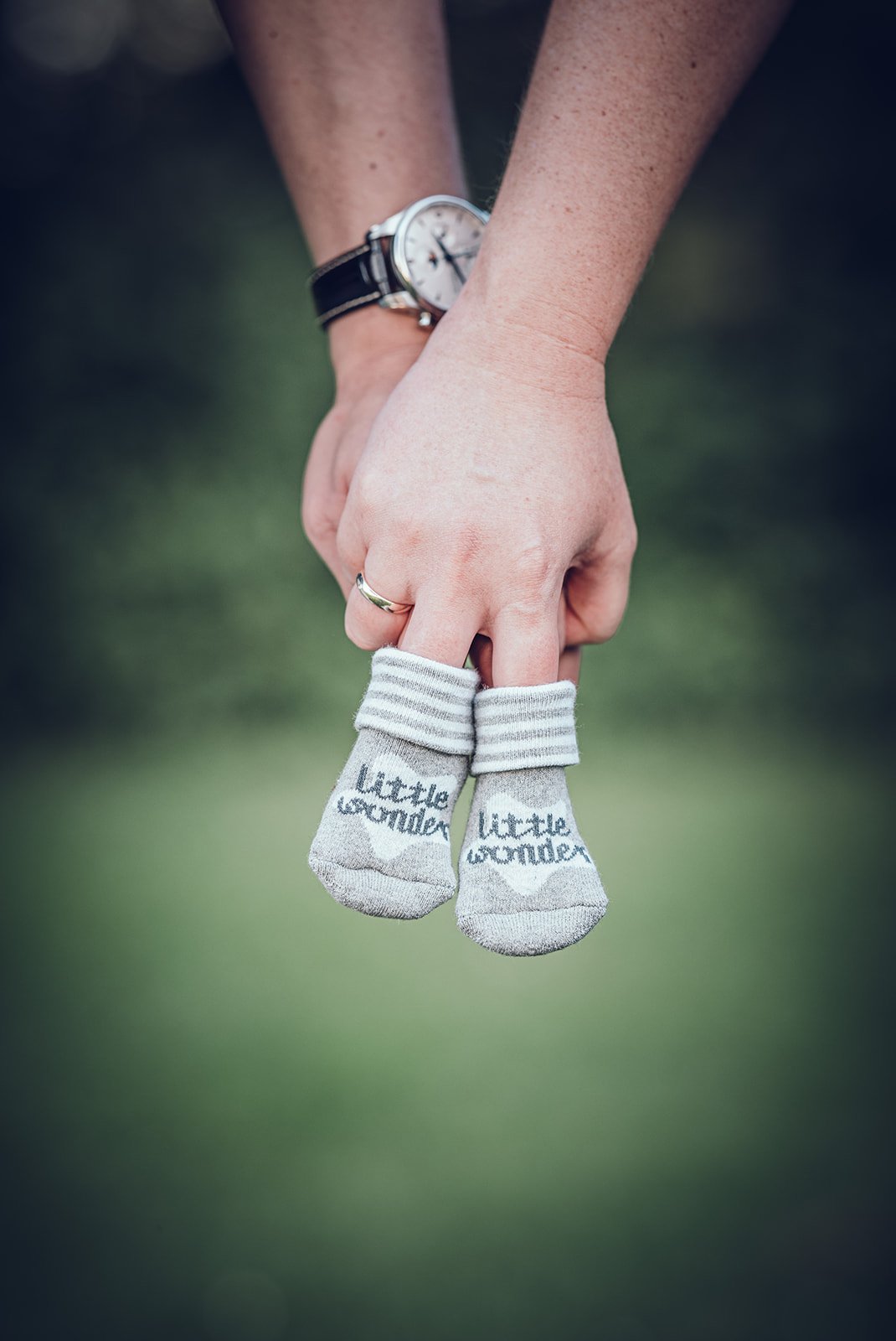 Hände halten kleine Babysöckchen – stimmungsvolles Detail aus der Babybauchfotografie in München