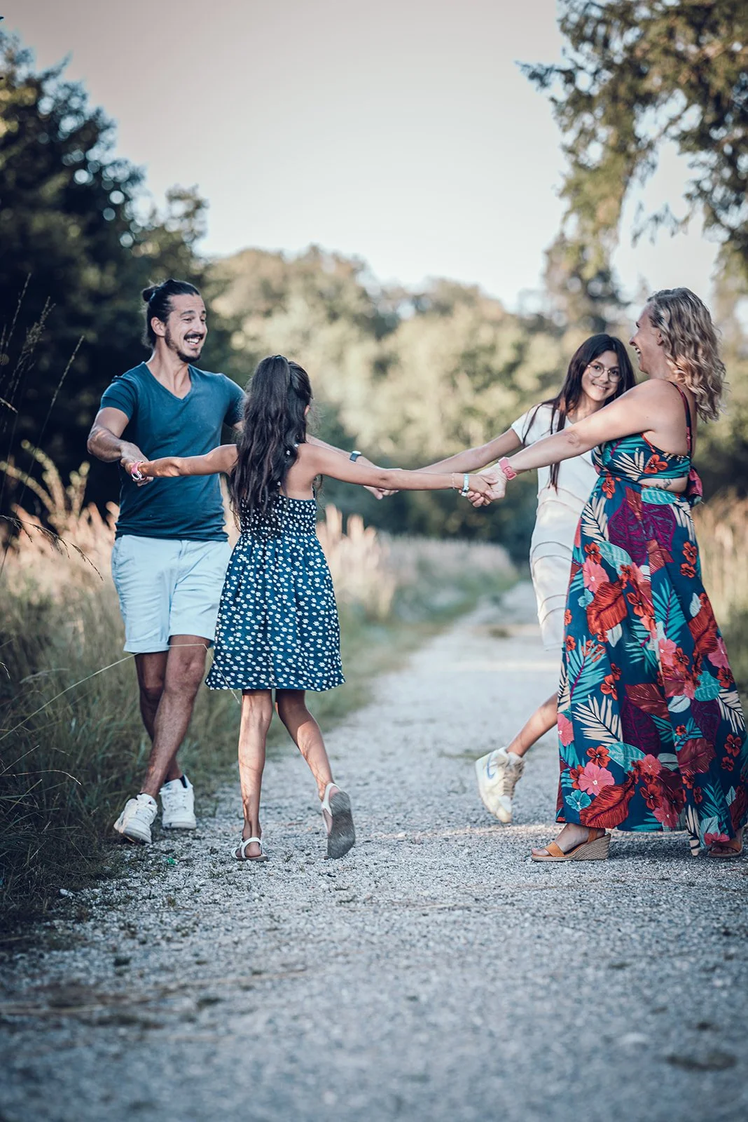 Familienfotografie in München – Familie tanzt auf Weg im Wald