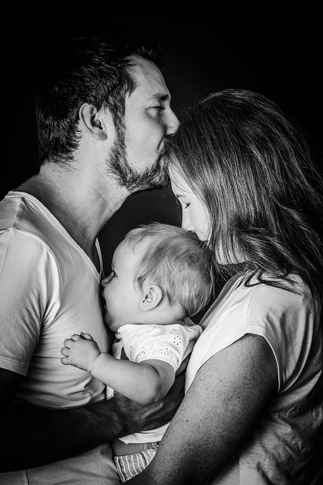 Familienmoment in Schwarz-Weiß – Eltern mit zwei kleinen Kindern in ruhiger, emotionaler Szene