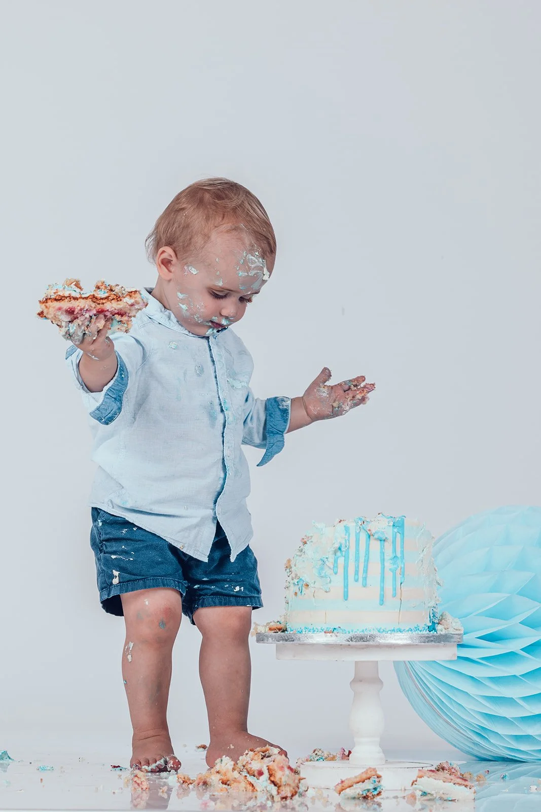 Baby beim Cake Smash Shooting mit Geburtstagstorte im Fotostudio in München