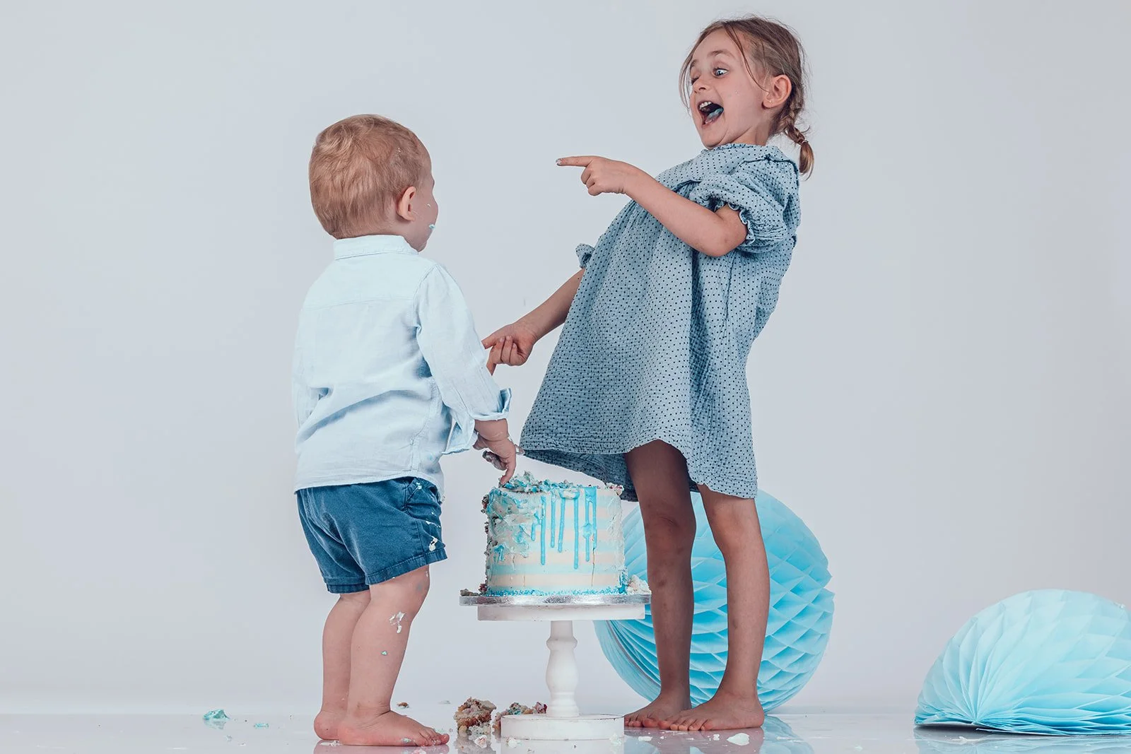 Geschwister beim Cake Smash Shooting mit Torte im Studio in München