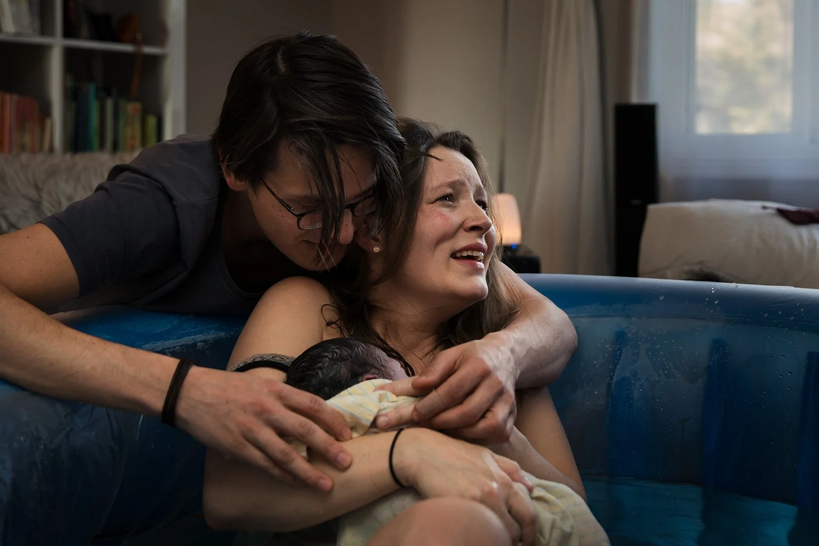 mother smiles with emotion after giving birth at home