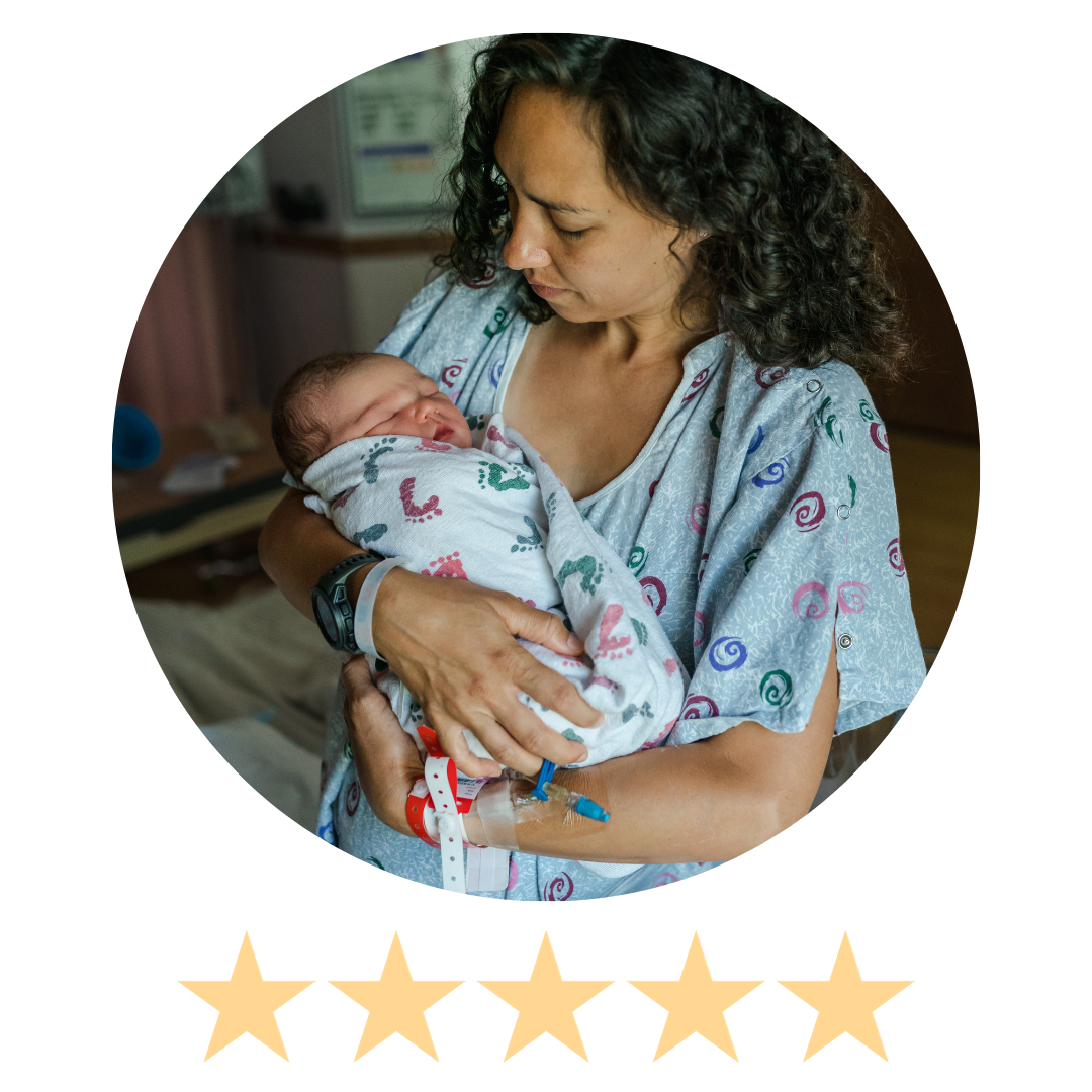 mother holds newborn in hospital gown after birth