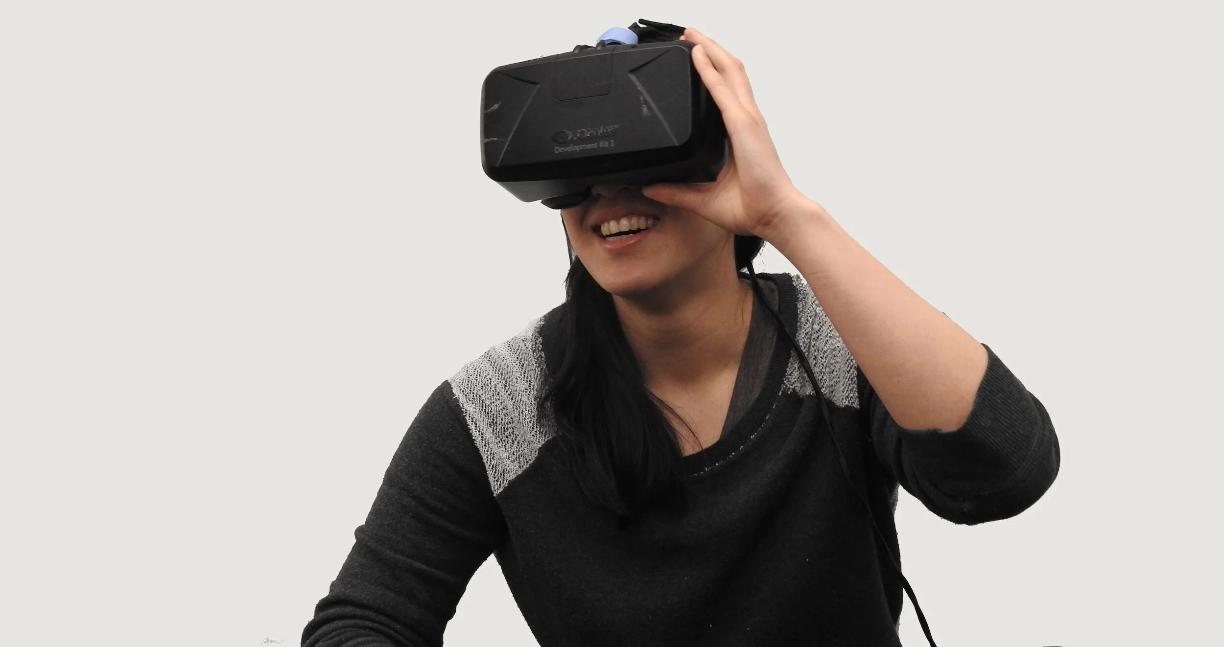Person wearing a virtual reality headset, smiling.